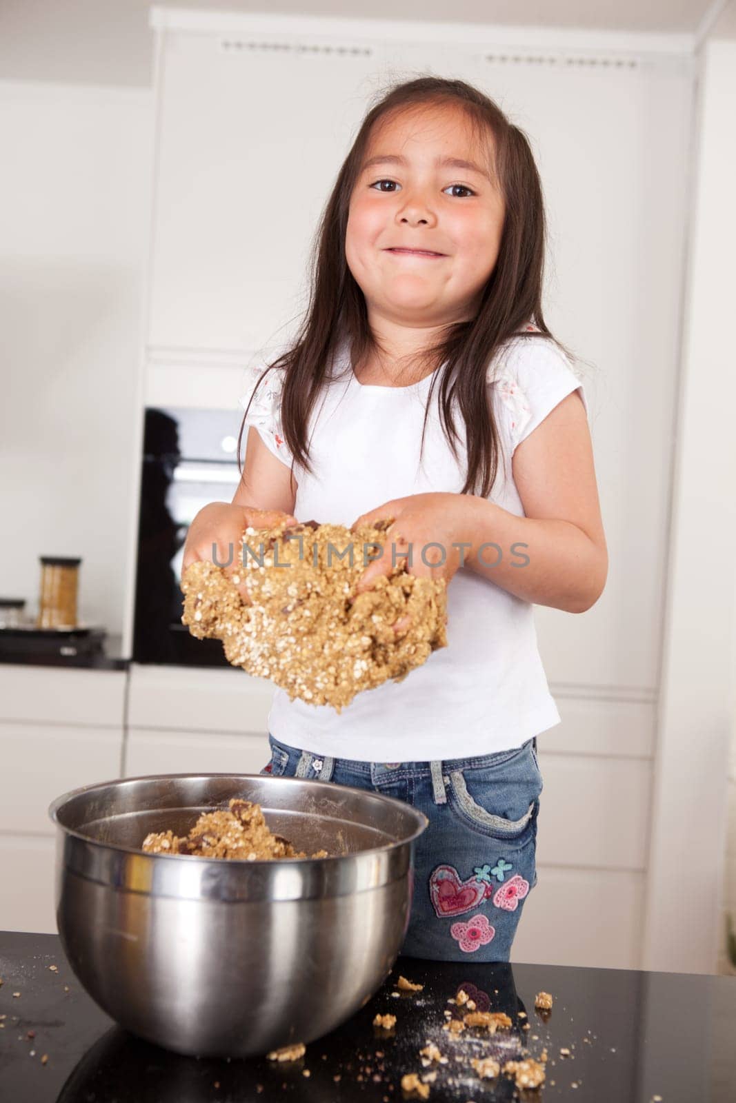 Young female child with hands full of cookie dough