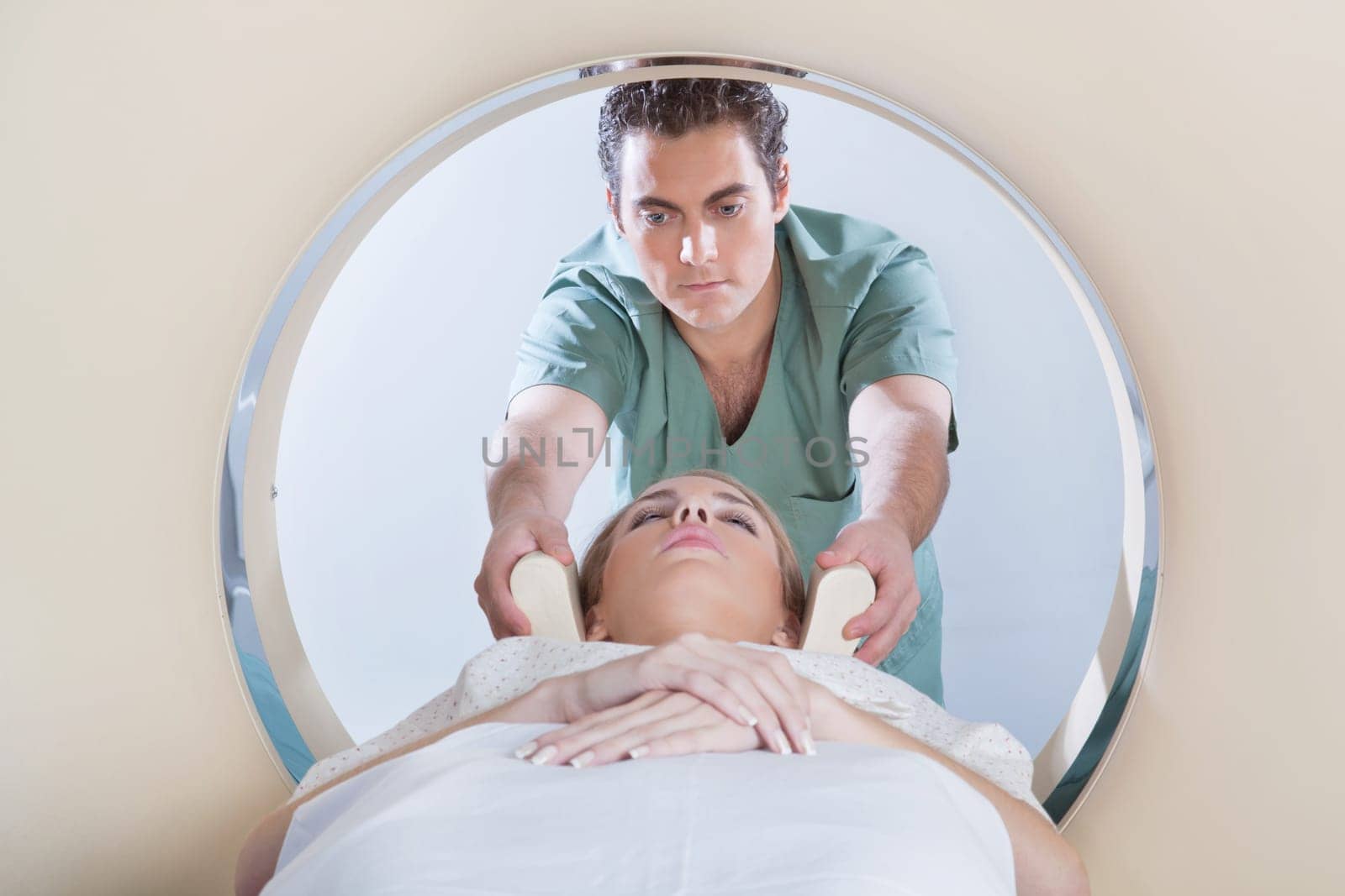 Nurse preparing young woman for CT scan test