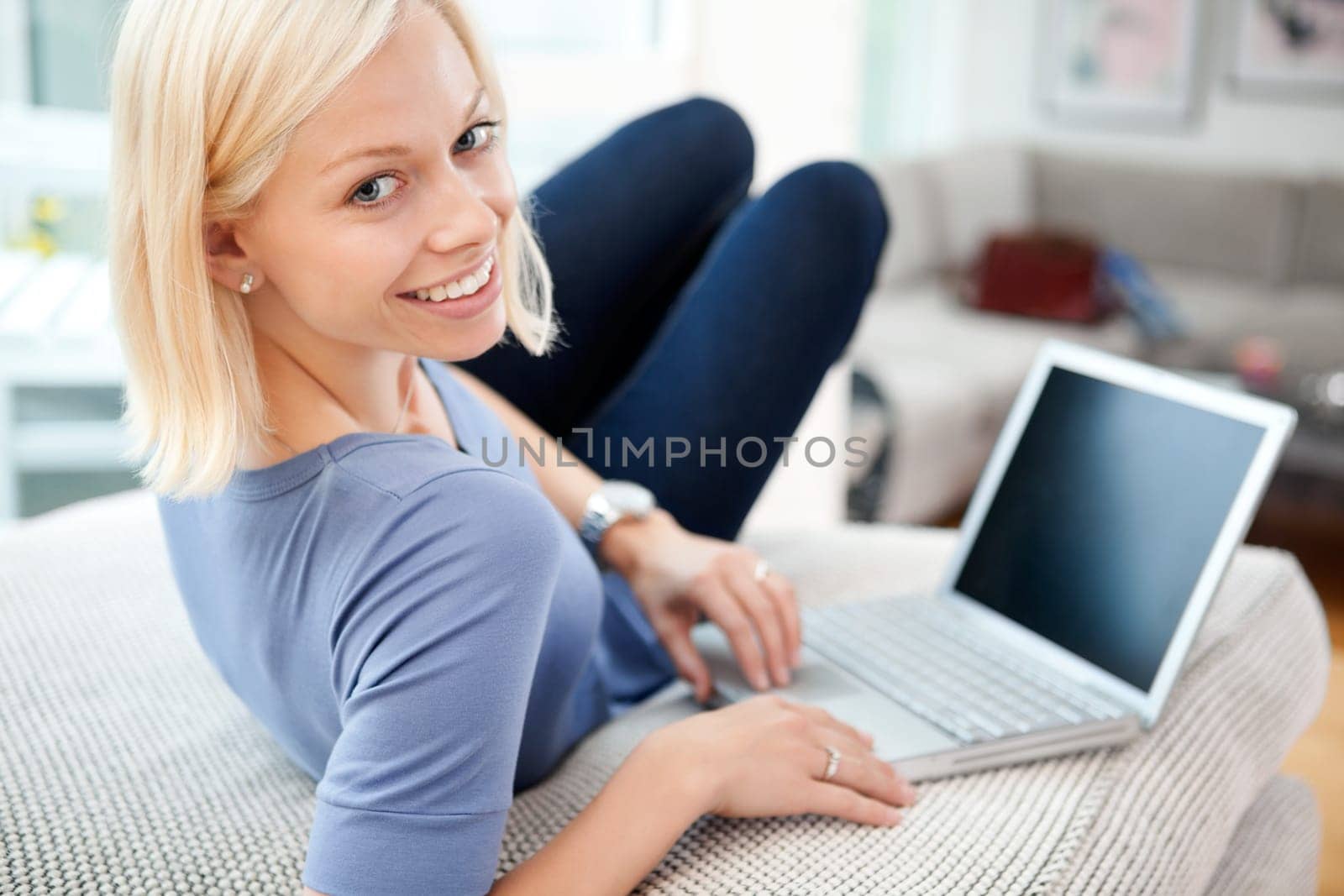 Portrait of happy blond woman using laptop