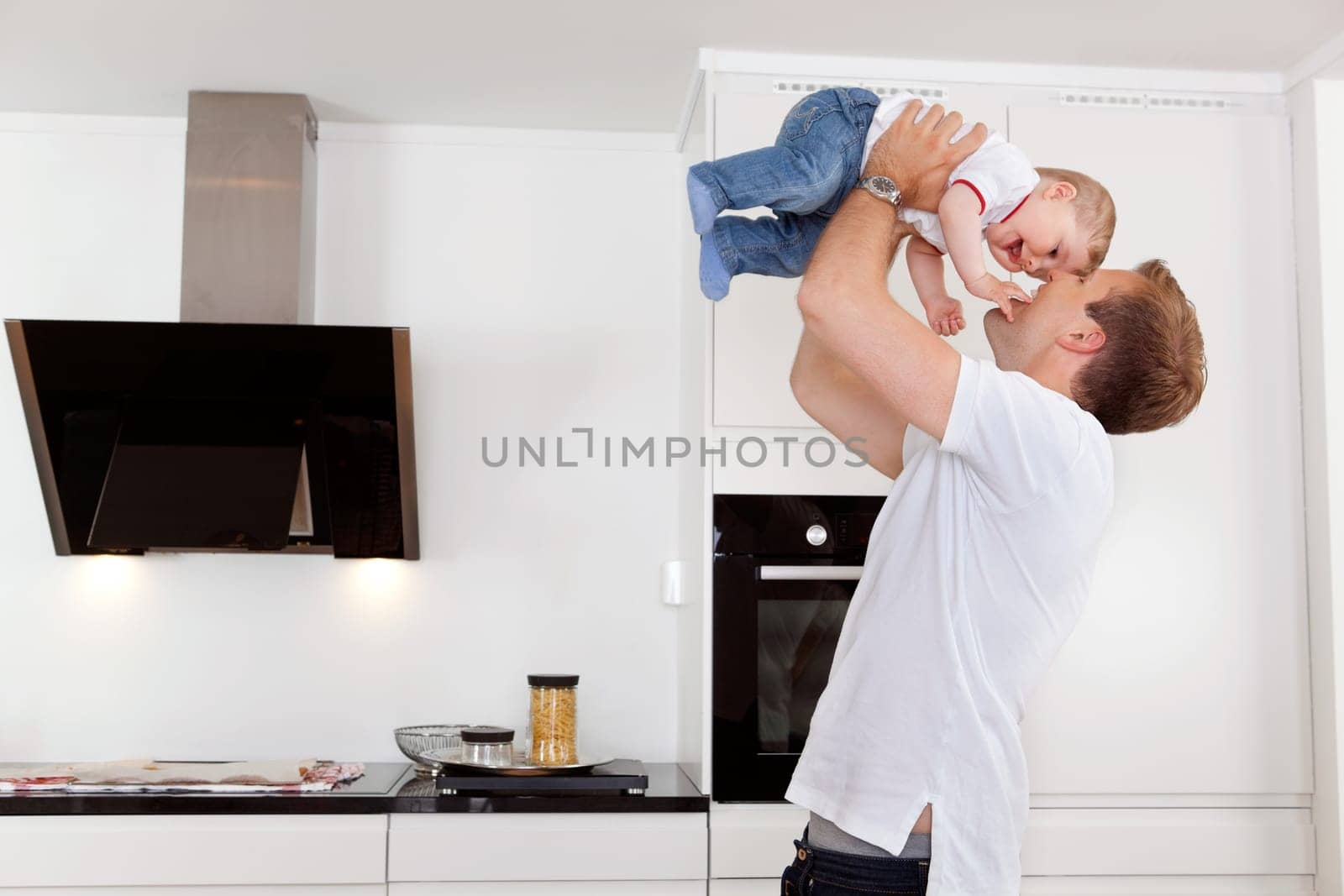Happy father holding his young child up