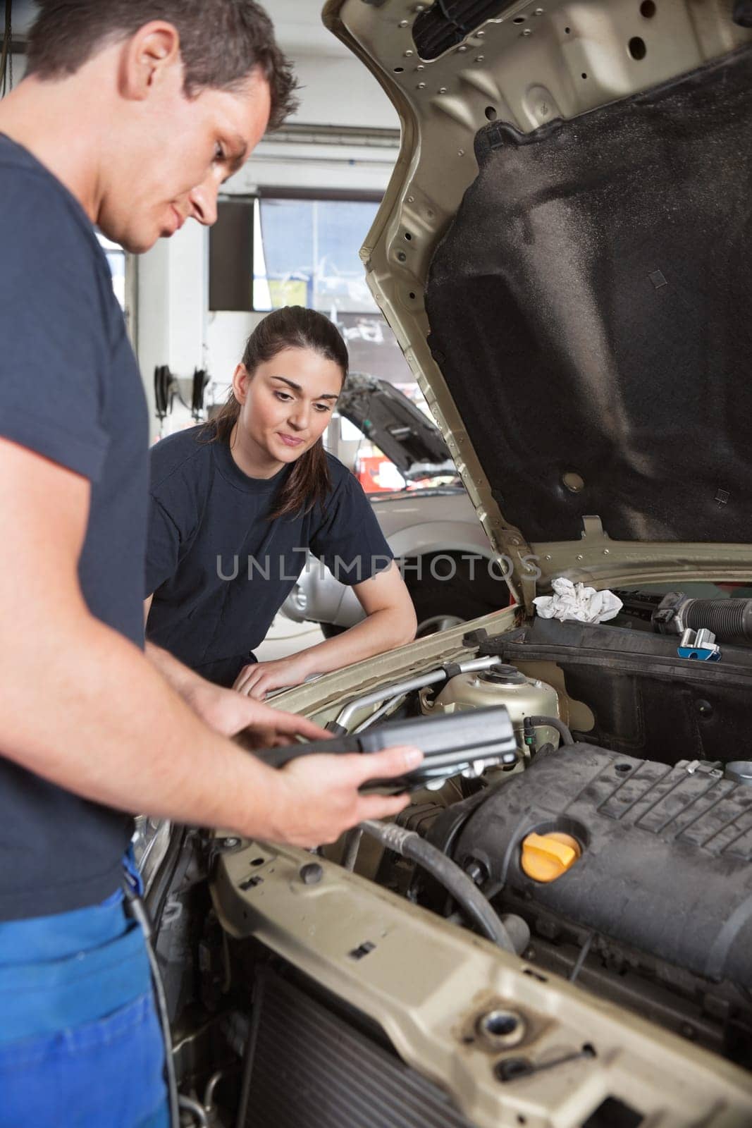 Two mechanic workers with diagnostics tool