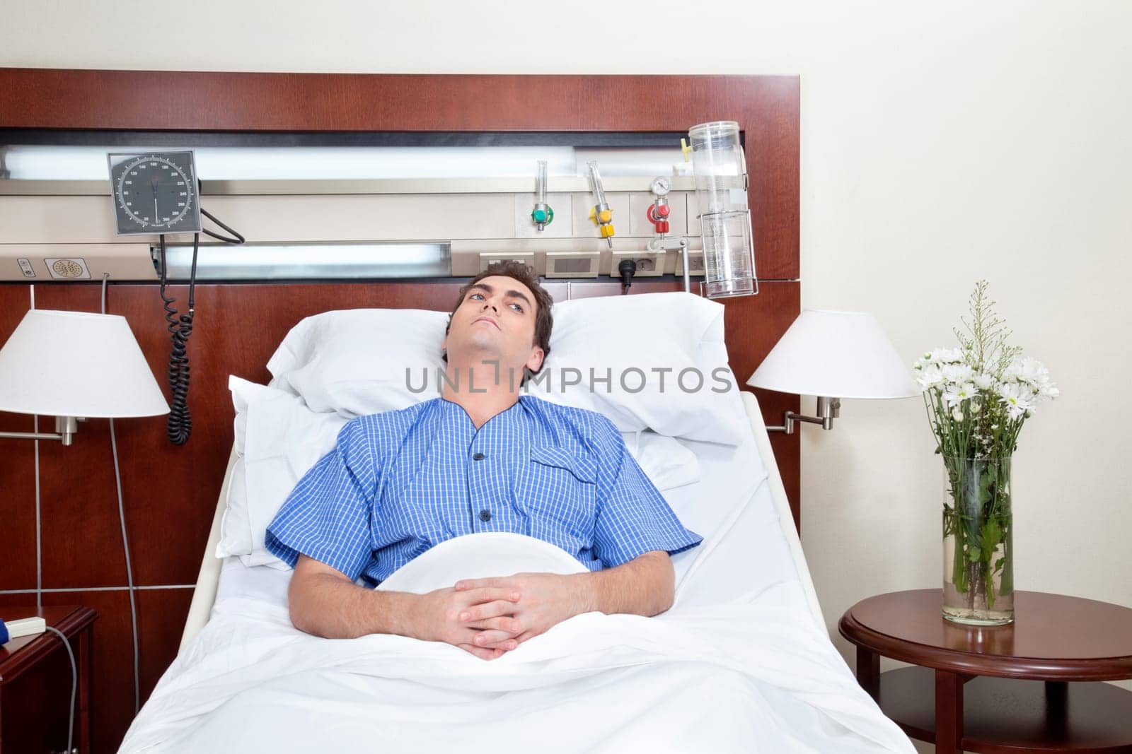 Thoughtful young patient lying on bed in hospital
