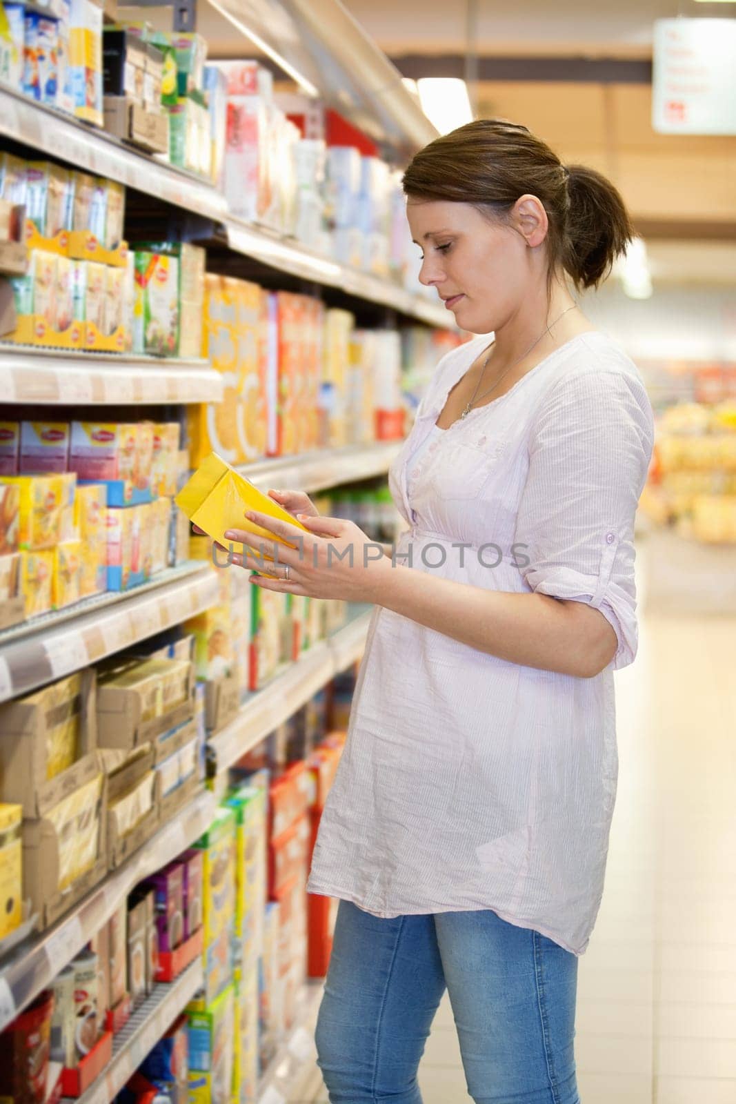 Woman takes a product from shelves at a supermarket