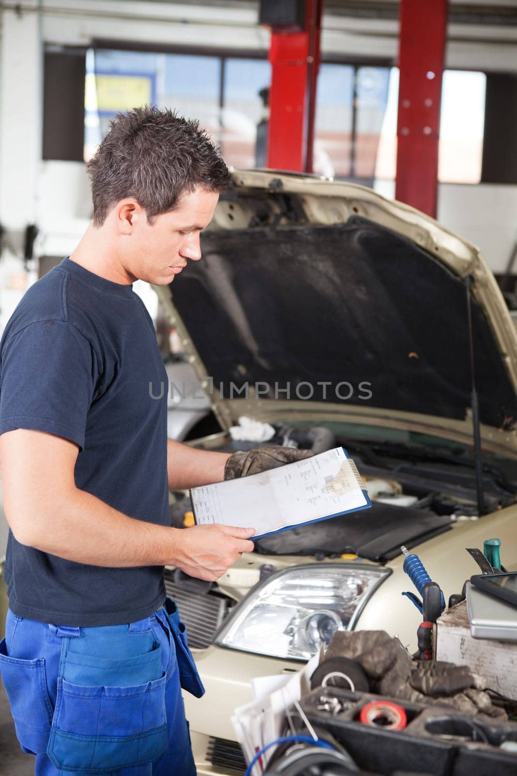 Three-quarter length of mechanic holding a work order