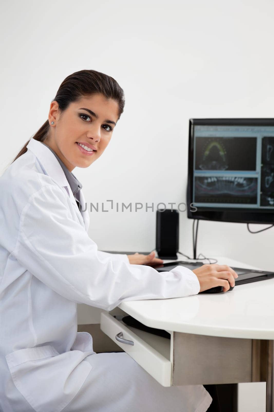 Portrait of female dentist with teeth x-ray on screen