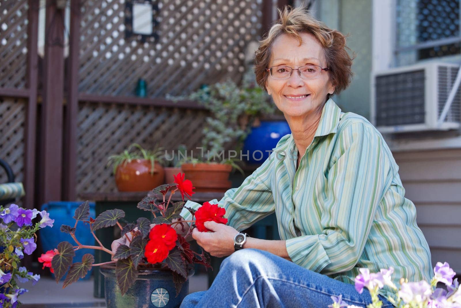Portrait of smiling senior woman with potted plant