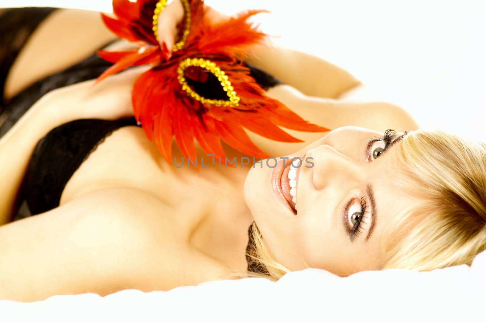 Portrait of attractive beautiful young woman on bed with red mask