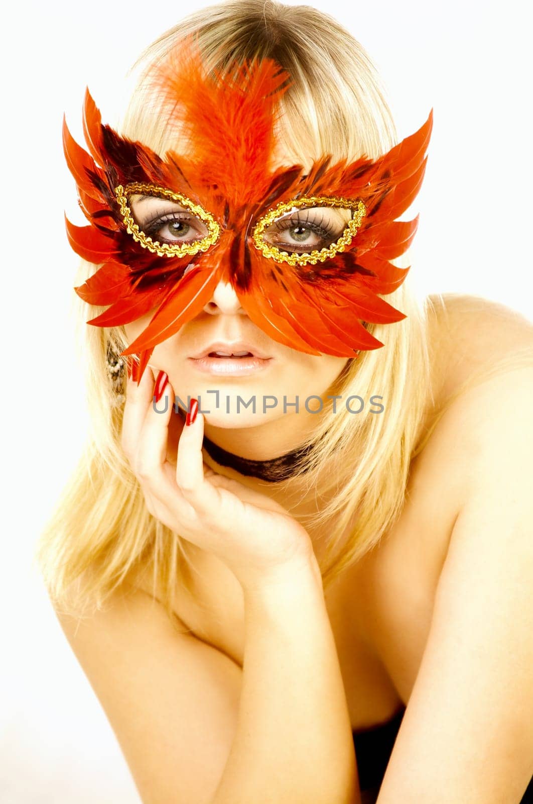 Portrait of attractive beautiful young woman on bed with red mask