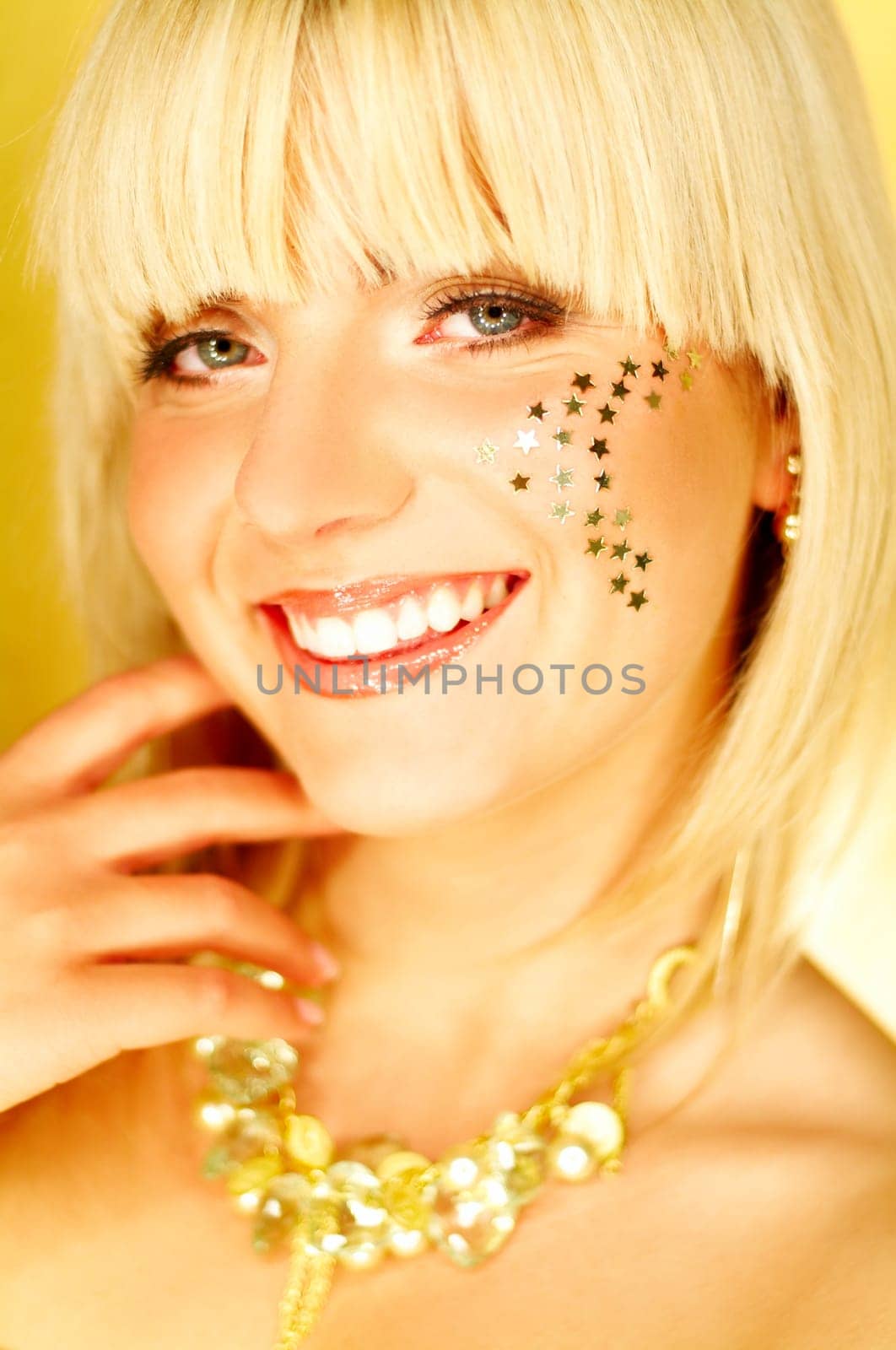 Portrait of beautiful young smiling woman with red lipstick and golden stars on chick