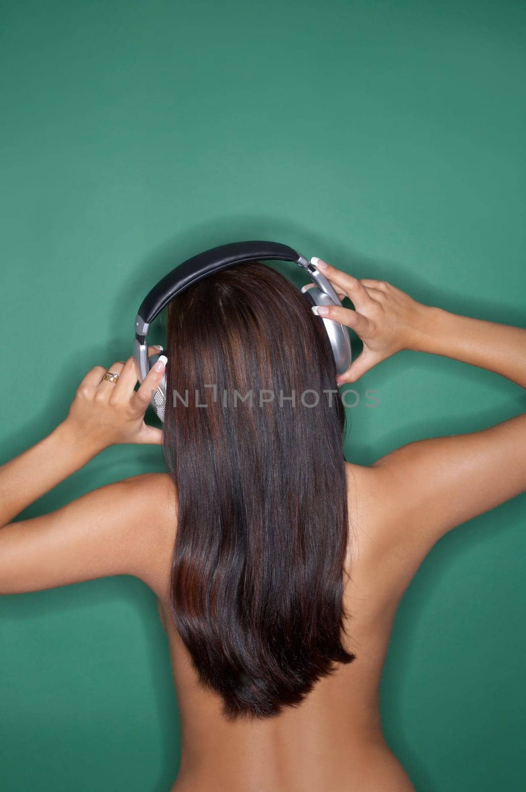 Portrait of Young woman isolated on green background with headphones