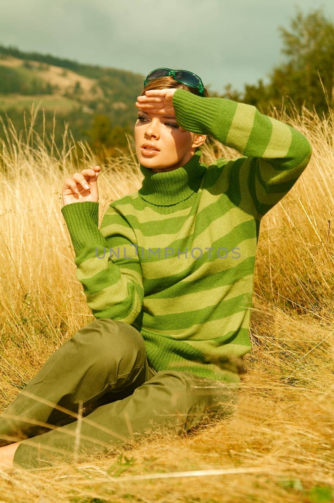 Young business woman relaxing on golden meadow at mountains outdoors