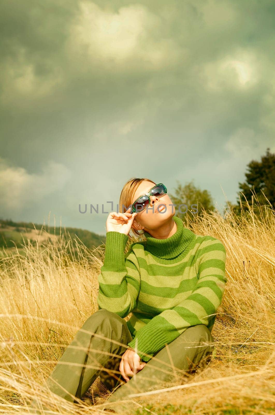 Young business woman relaxing on golden meadow at mountains outdoors