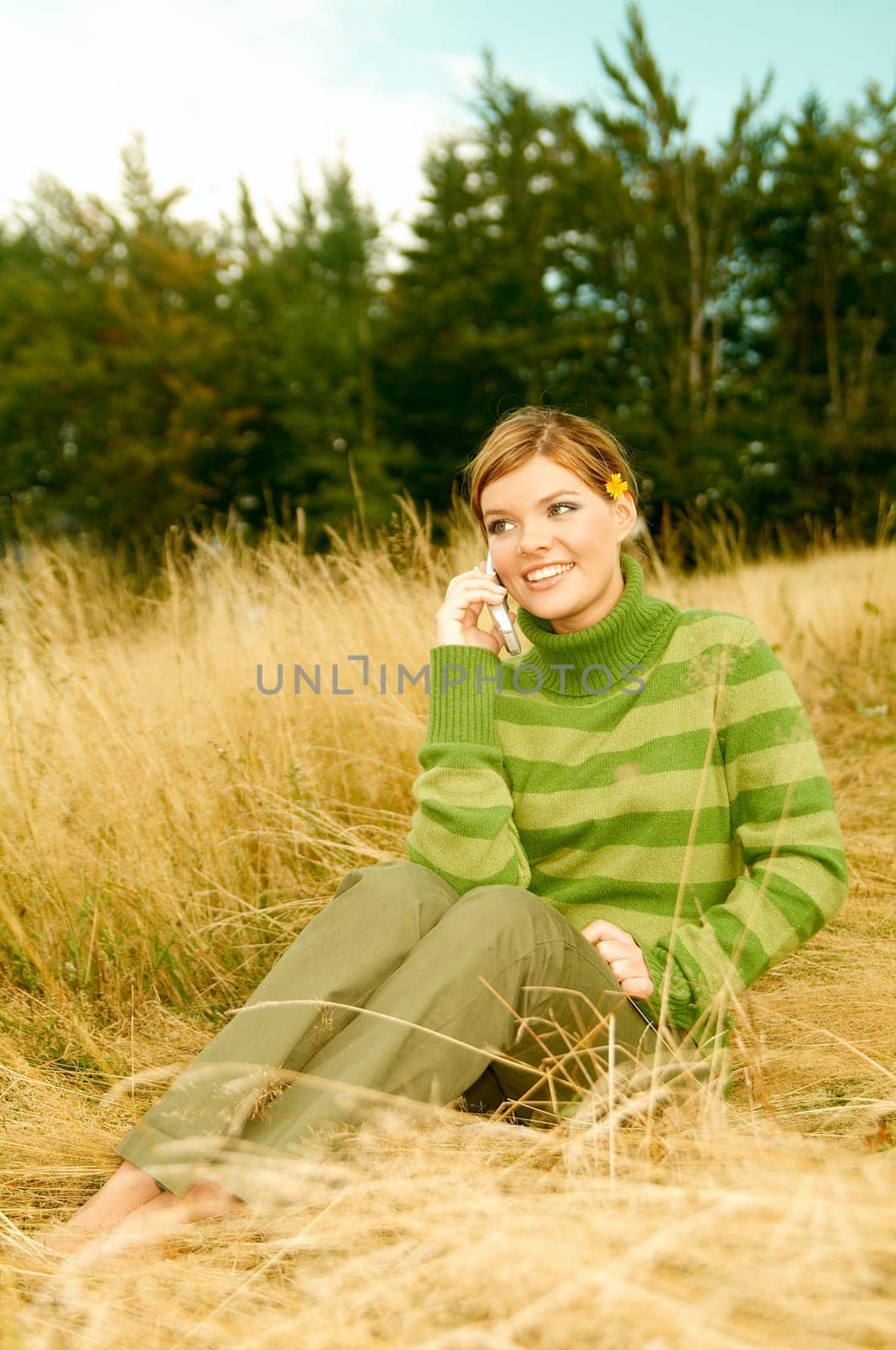 Young business woman using cell phone on golden meadow at mountains outdoors