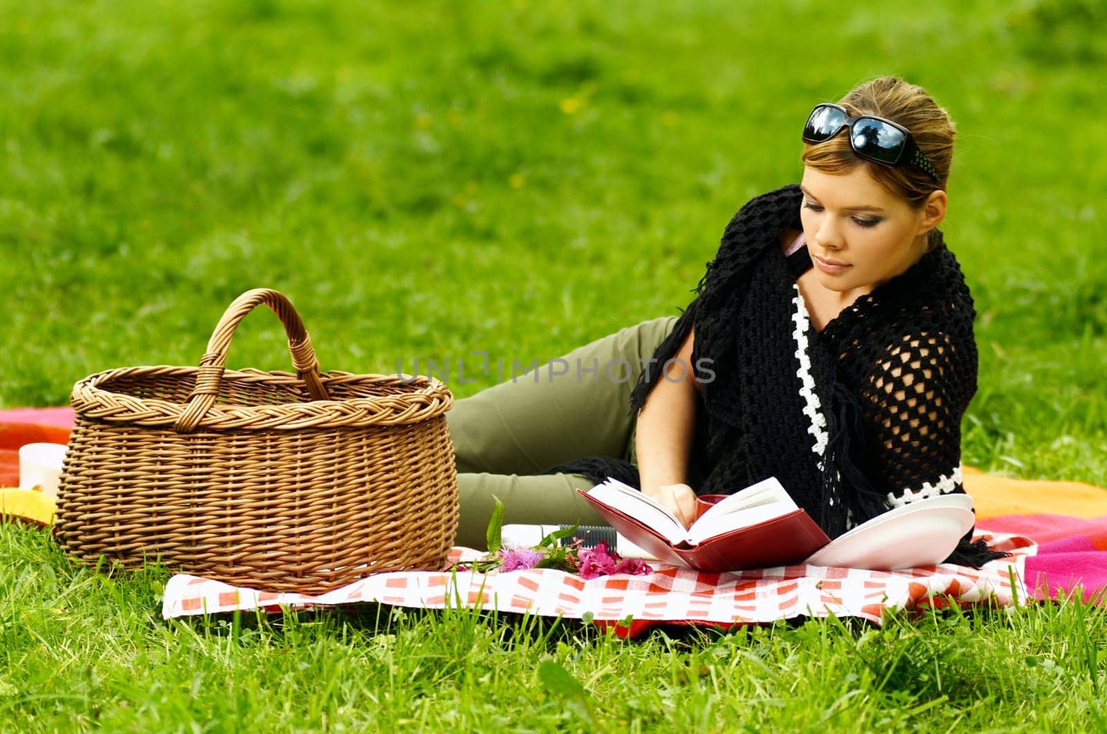 Young business woman with book during picnic on green meadows outdoors