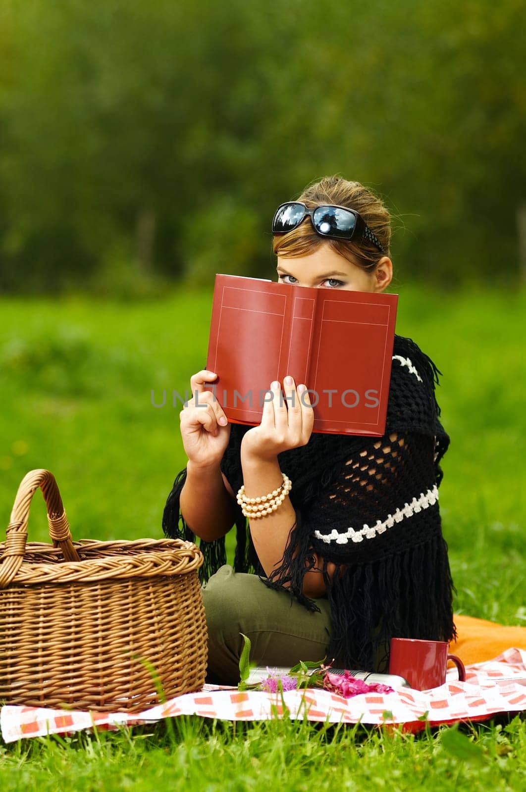 Young business woman with book during picnic on green meadows outdoors