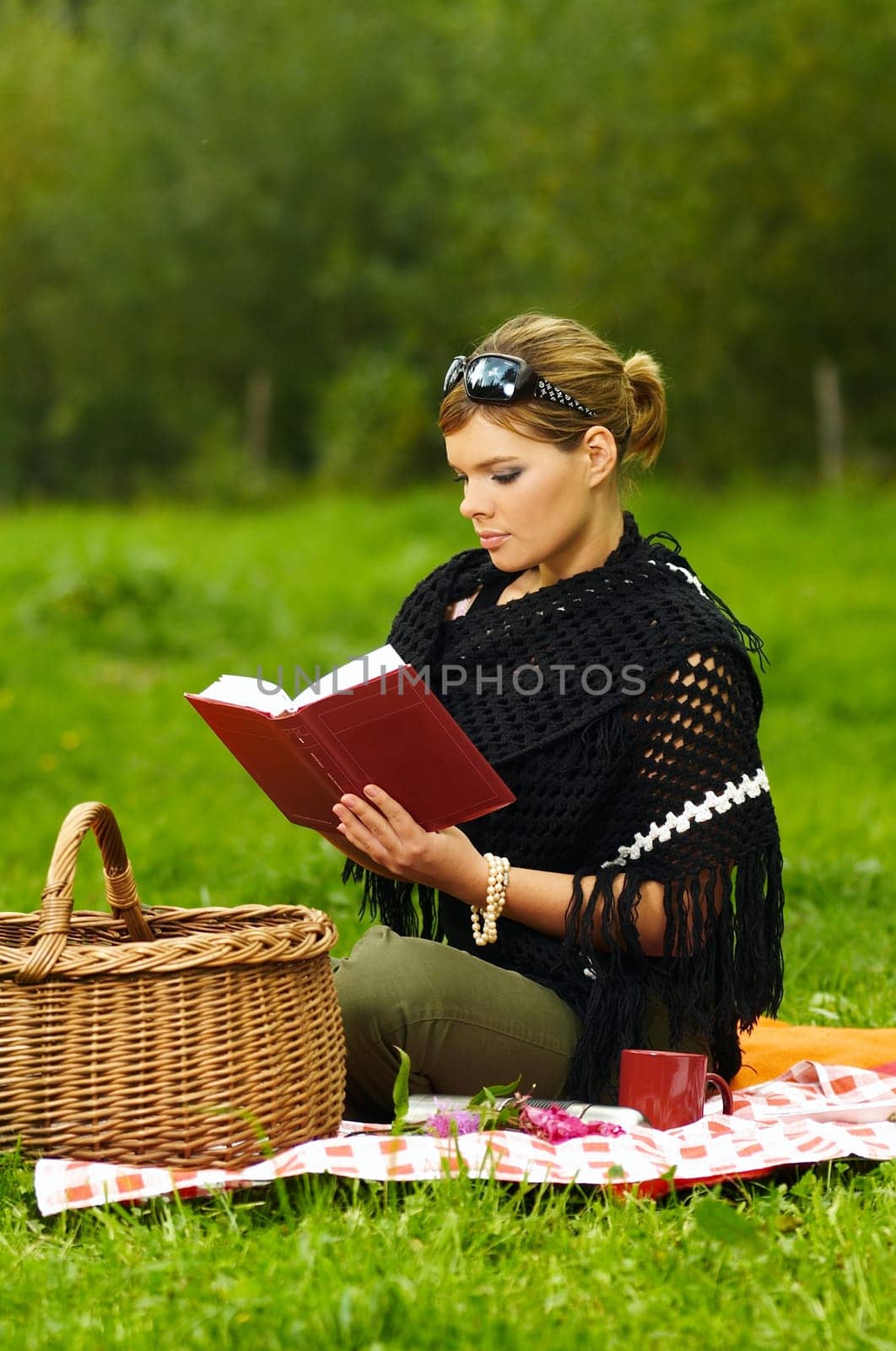 Young business woman with book during picnic on green meadows outdoors