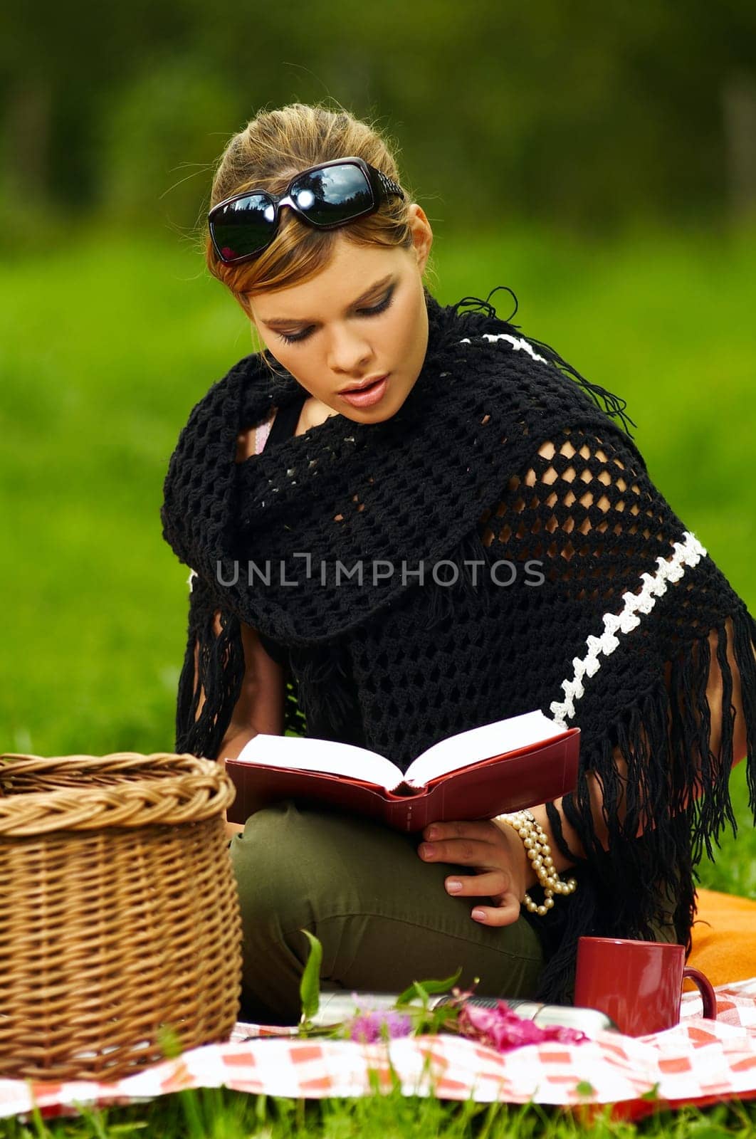 Young business woman with book during picnic on green meadows outdoors