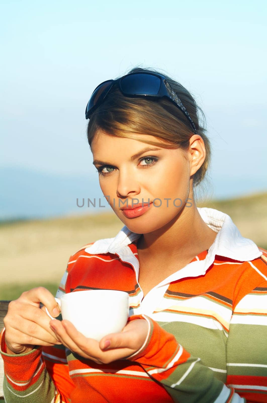 Young woman relaxing, drinking coffee at mouintain outdoors