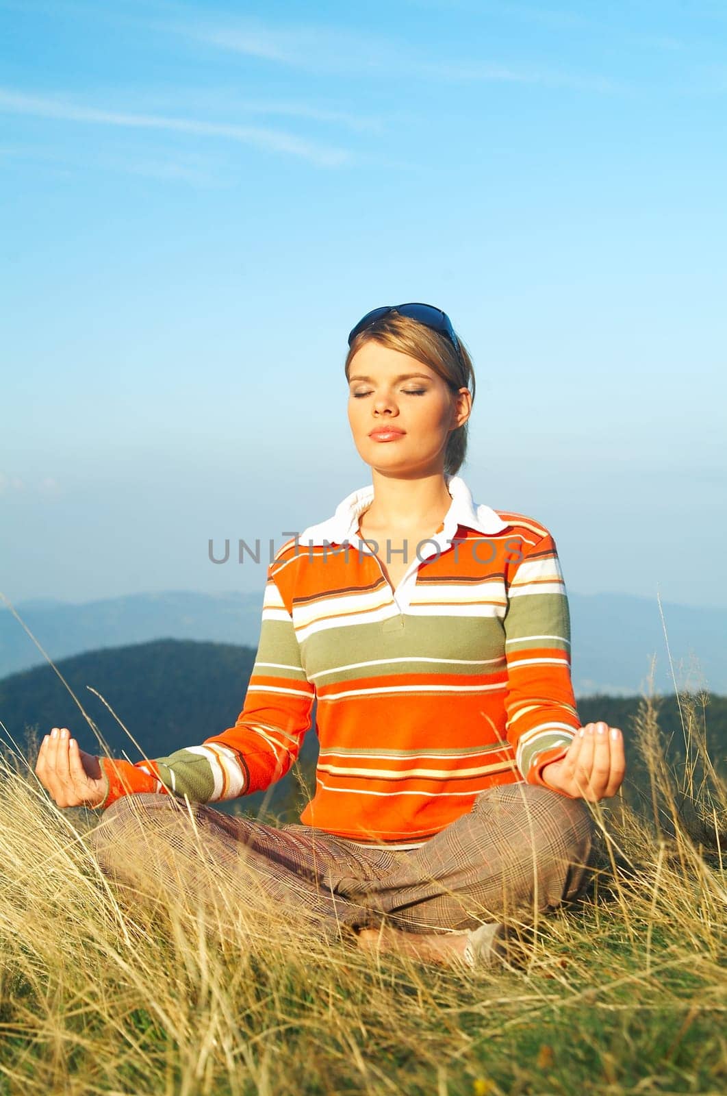 Young beautiful woman relaxing on meadow at mouintain outdoors