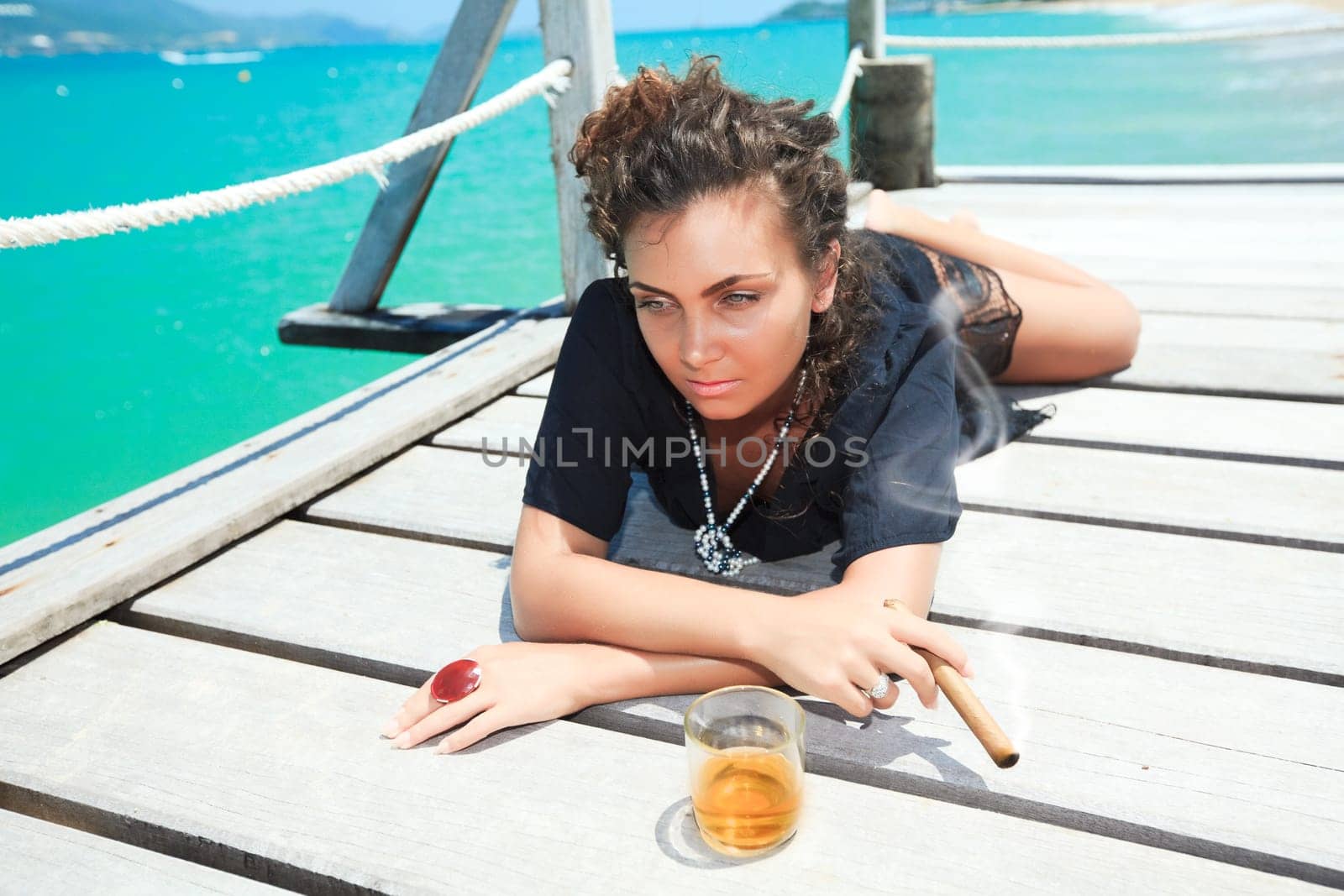 Young woman with cigar and a glass of whiskey