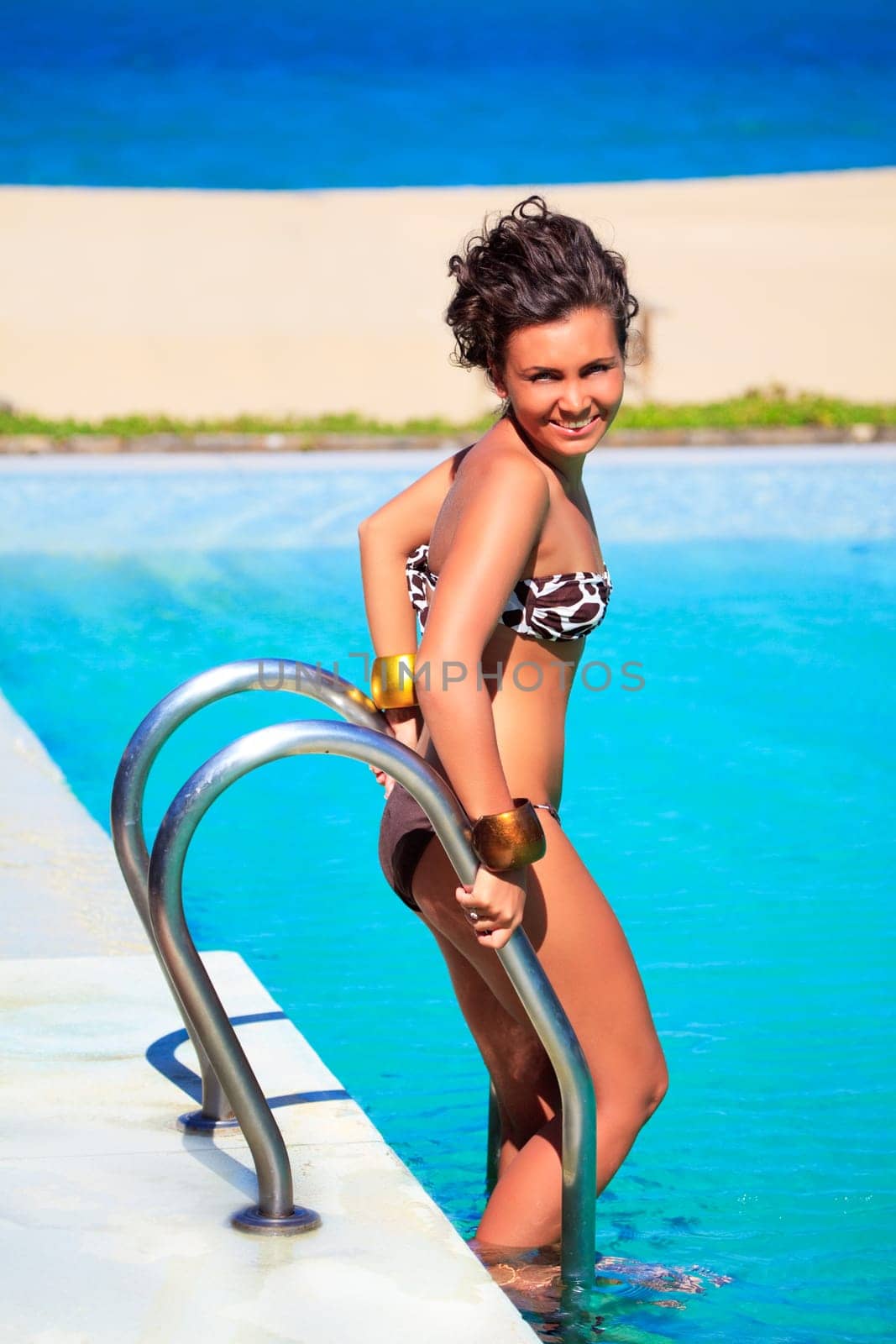 Young beautiful smiling woman in swimming pool