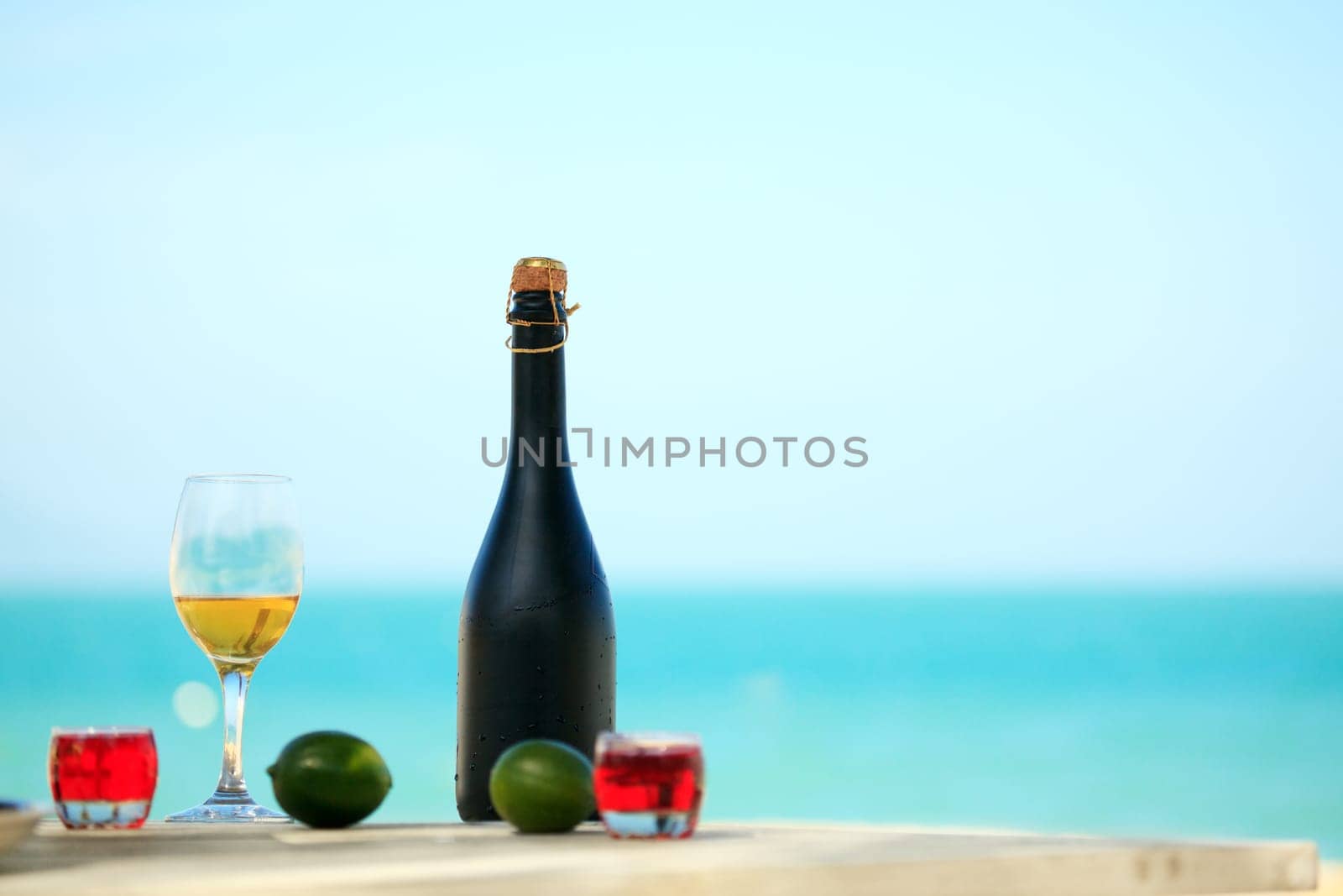 Bottle and glass of wine on the beach