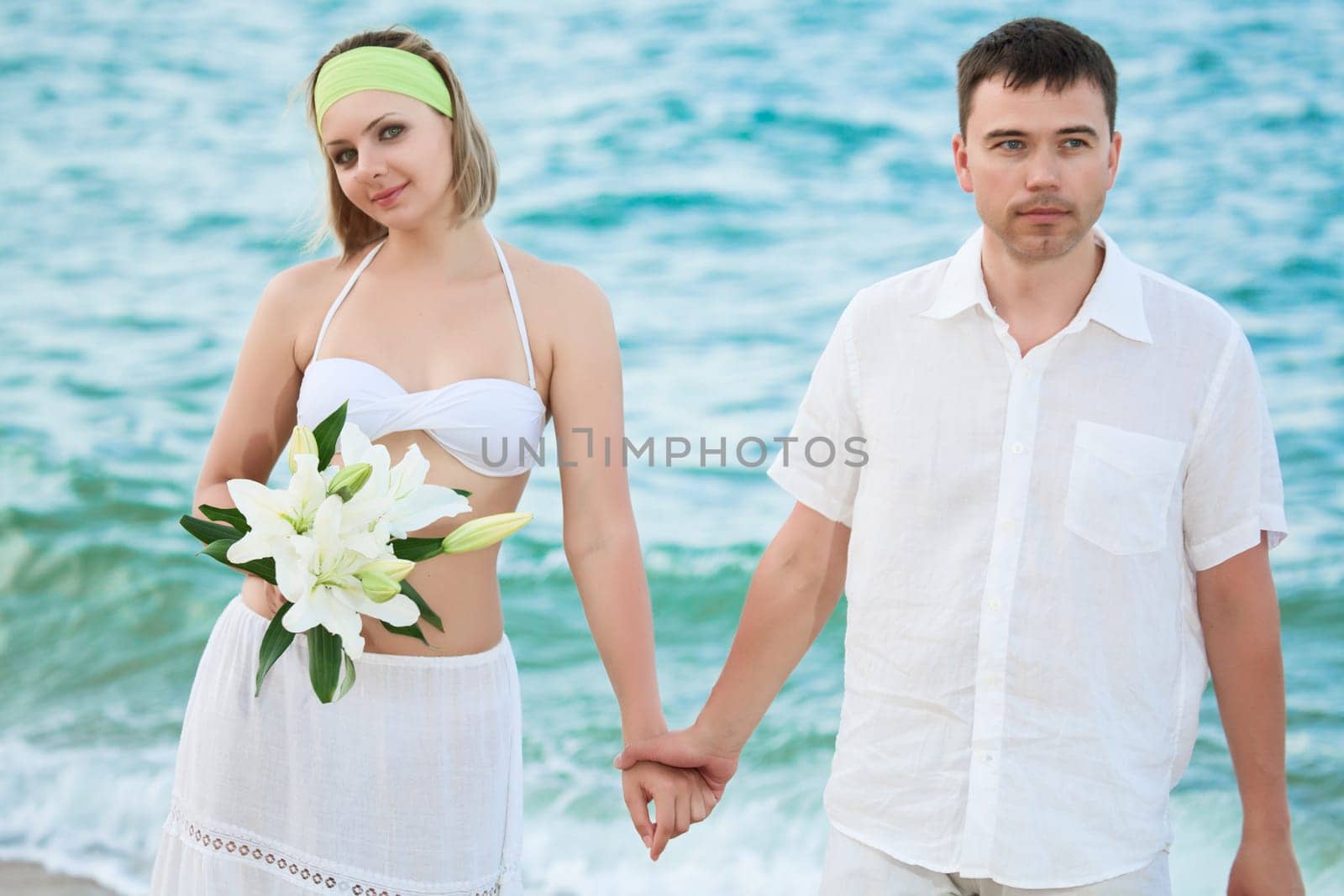 Romantic couple near the ocean with flowers