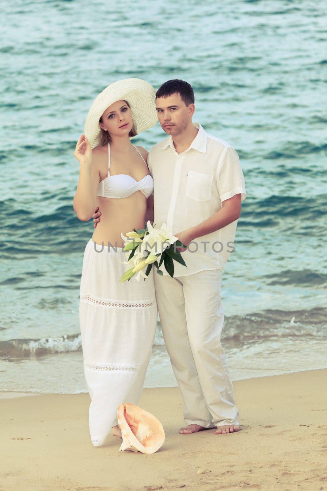 Romantic couple near the ocean with flowers
