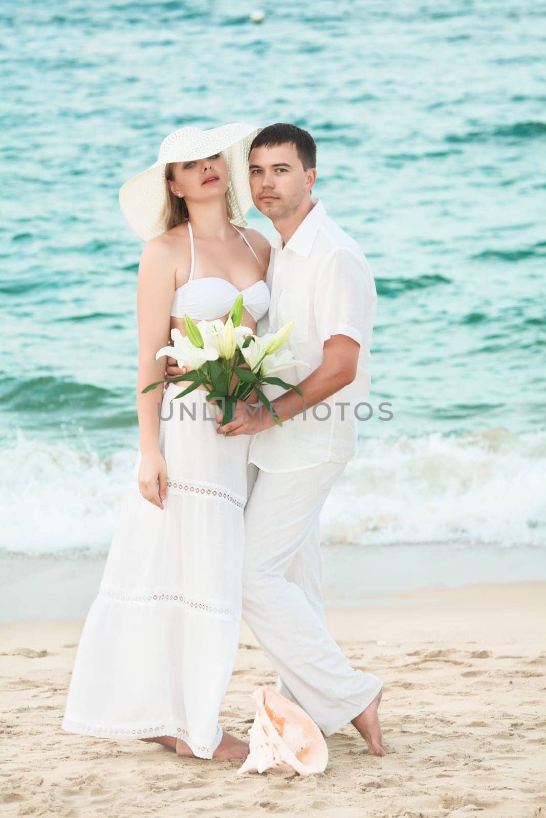 Romantic couple near the ocean with flowers