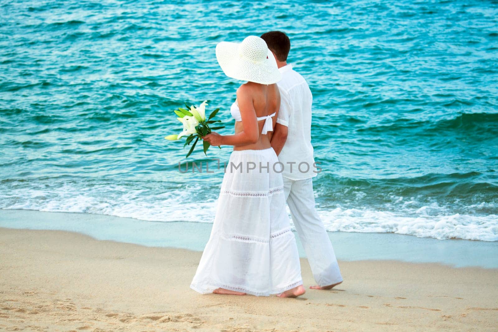 Romantic young couple walking along the sea