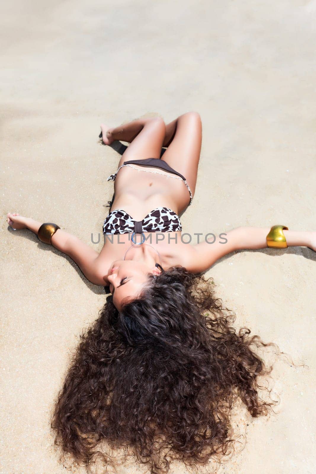 Young beautiful woman sunbathing on the sand