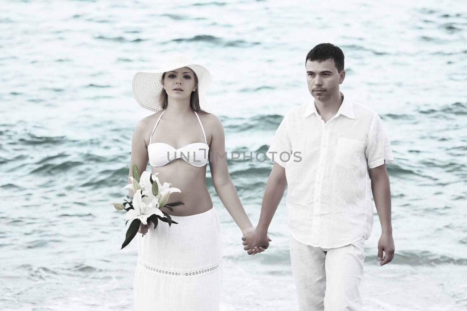 Romantic couple near the ocean with flowers