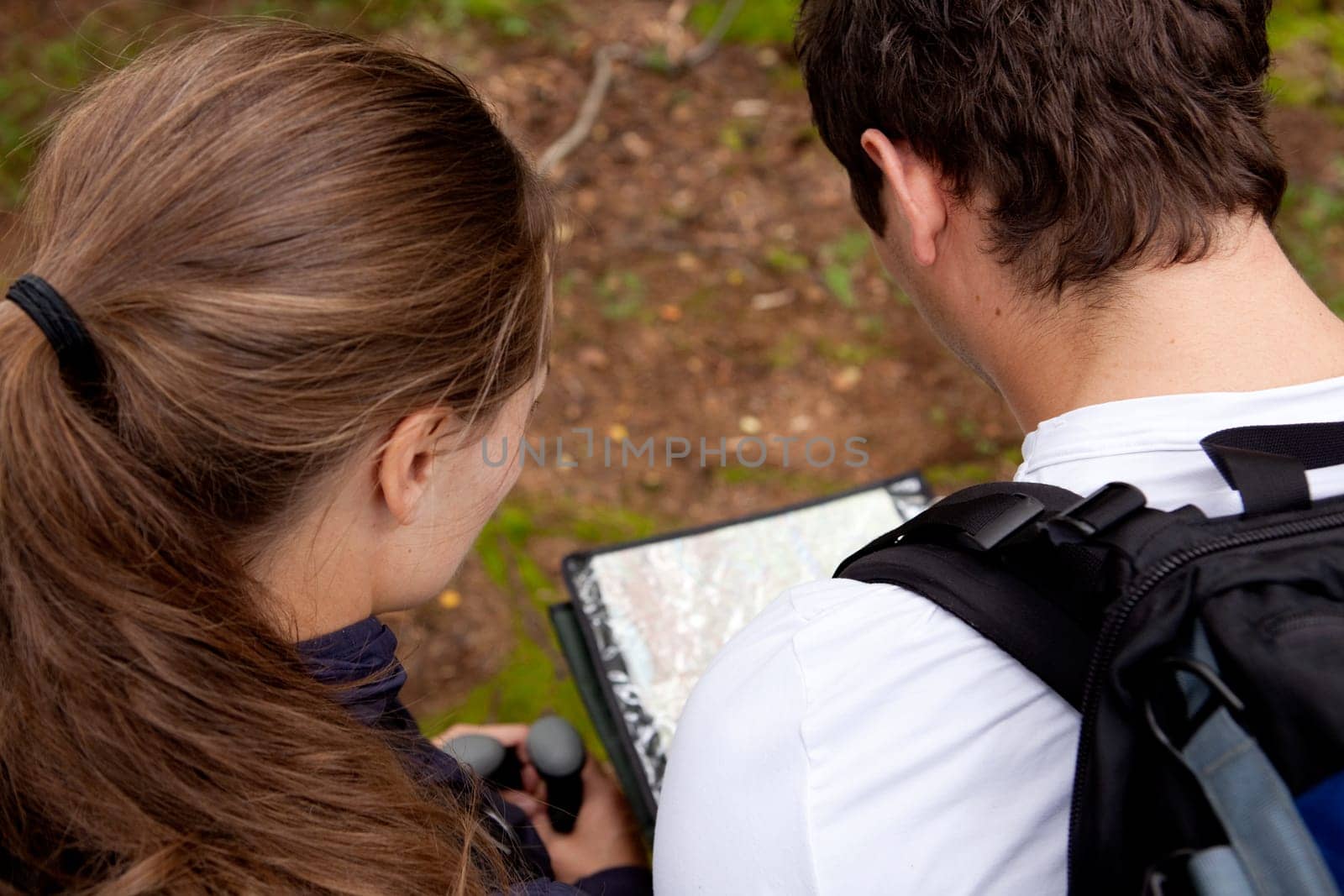 A couple orienteering with a map while camping