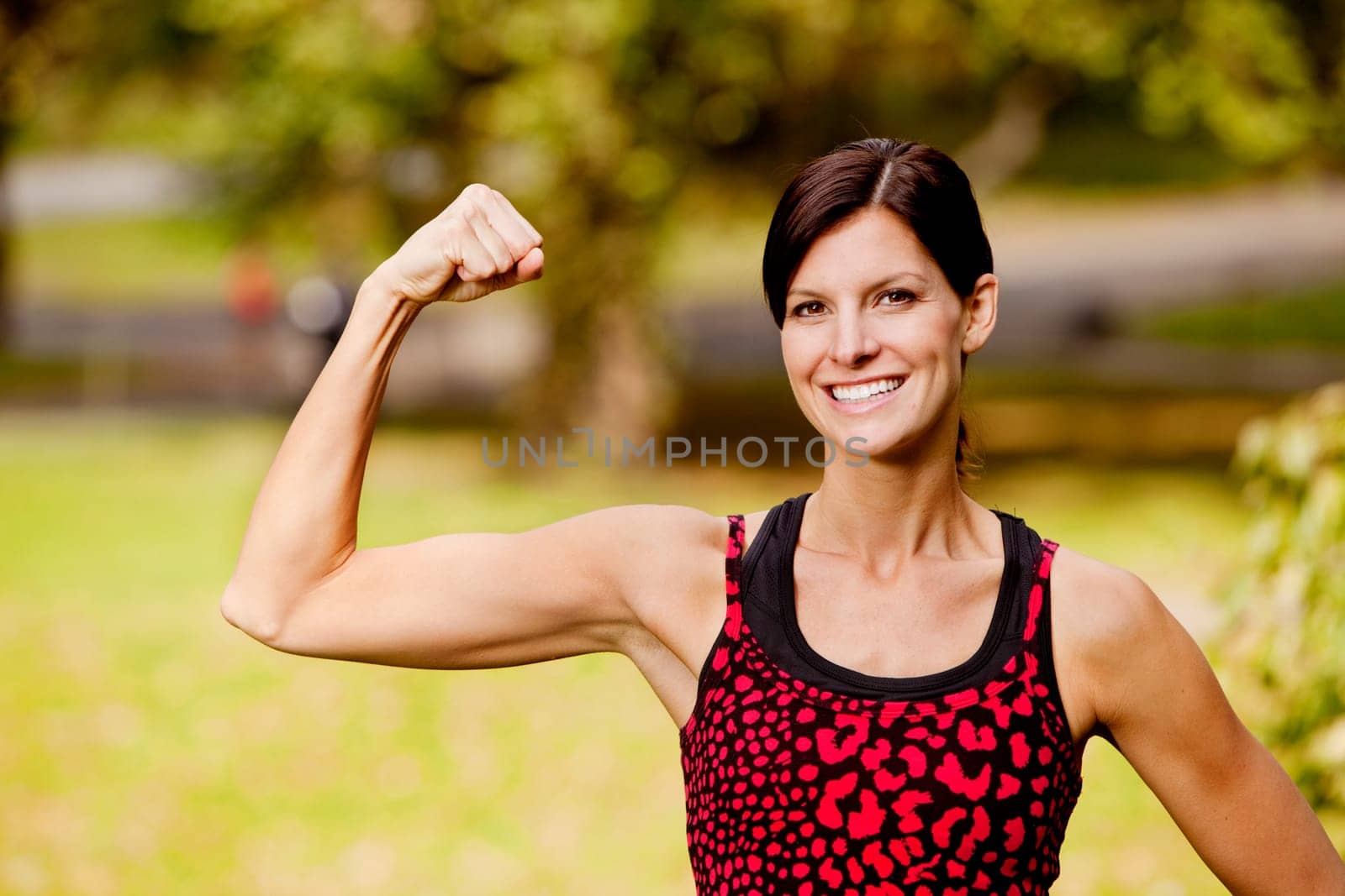 A pretty fitness model flexing her bicep