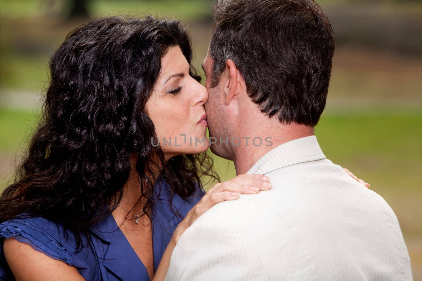 A woman giving a man a kiss on the cheek