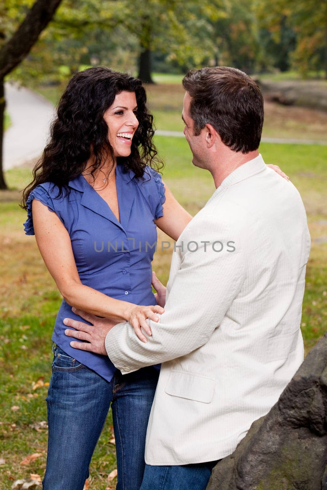 A happy couple in the park laughing and talking