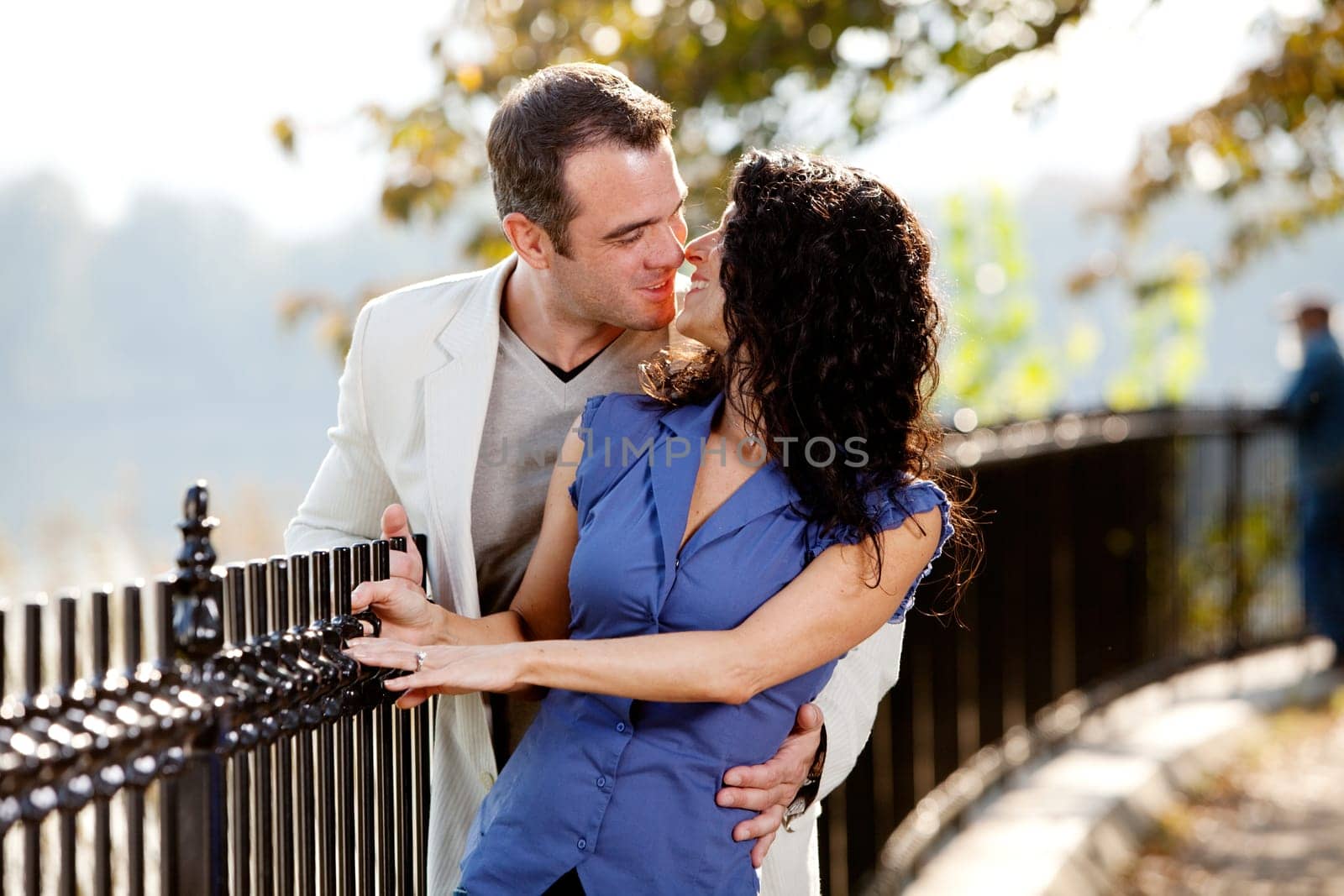 A happy couple kissing in the park on a beautiful day