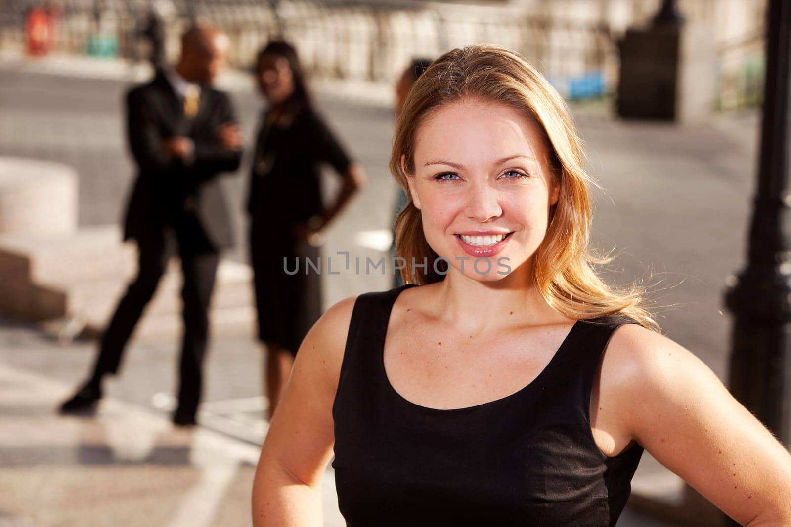Three business people with one woman as focus. Horizontally framed shot.