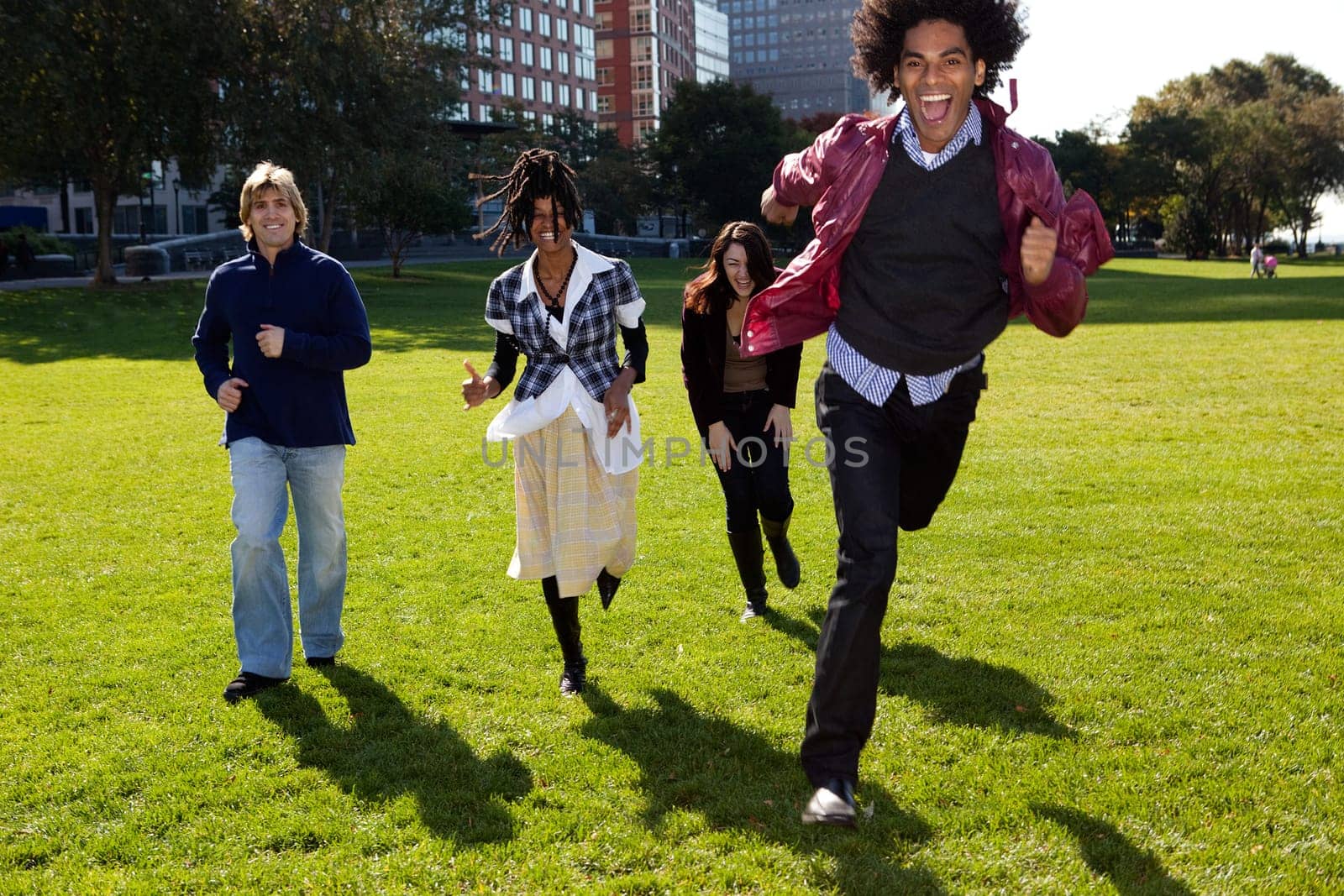 Four people running in urban park. Vertically framed shot.