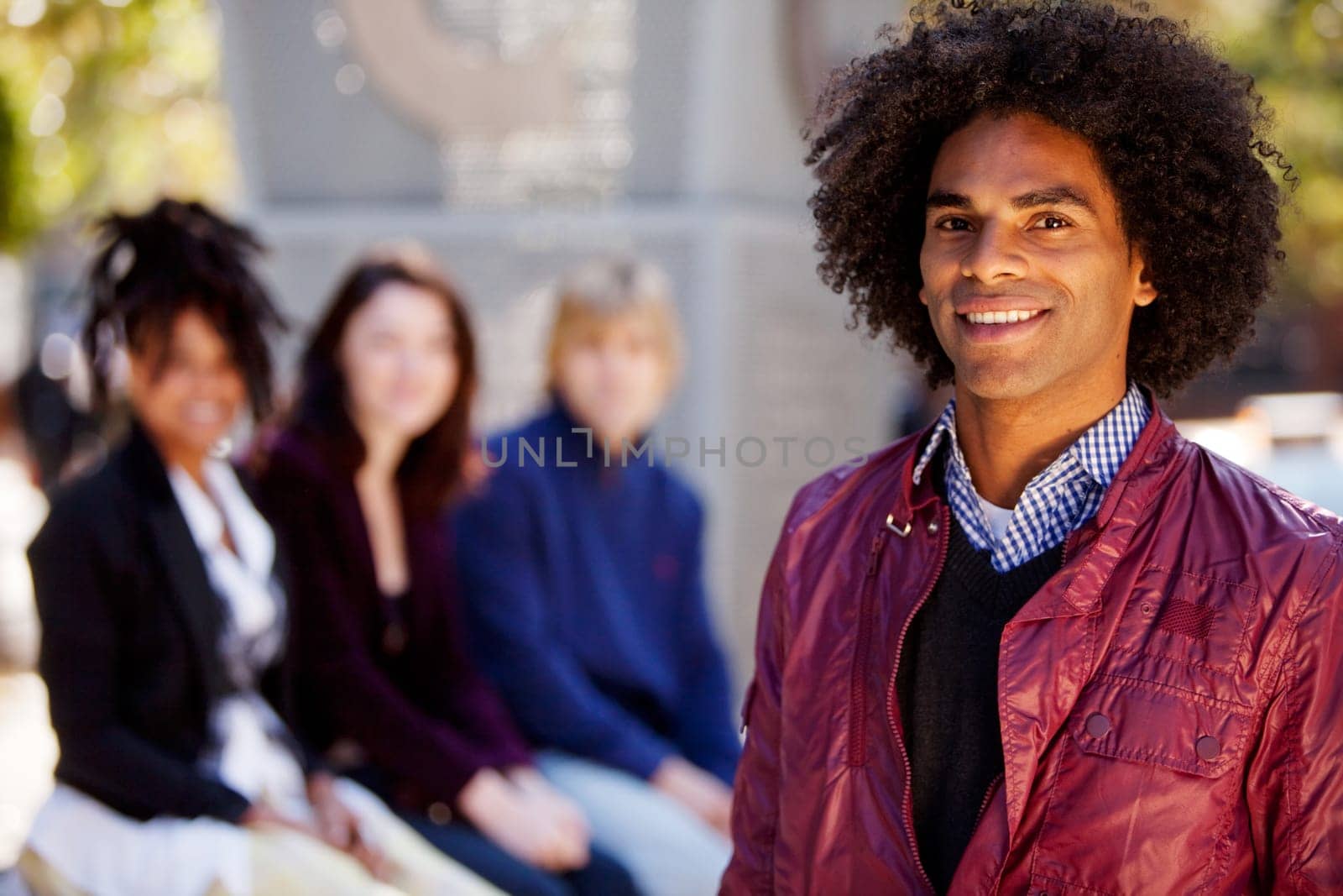 Group of four people of different ethnicities with one man as focus of image. Horizontally framed shot.
