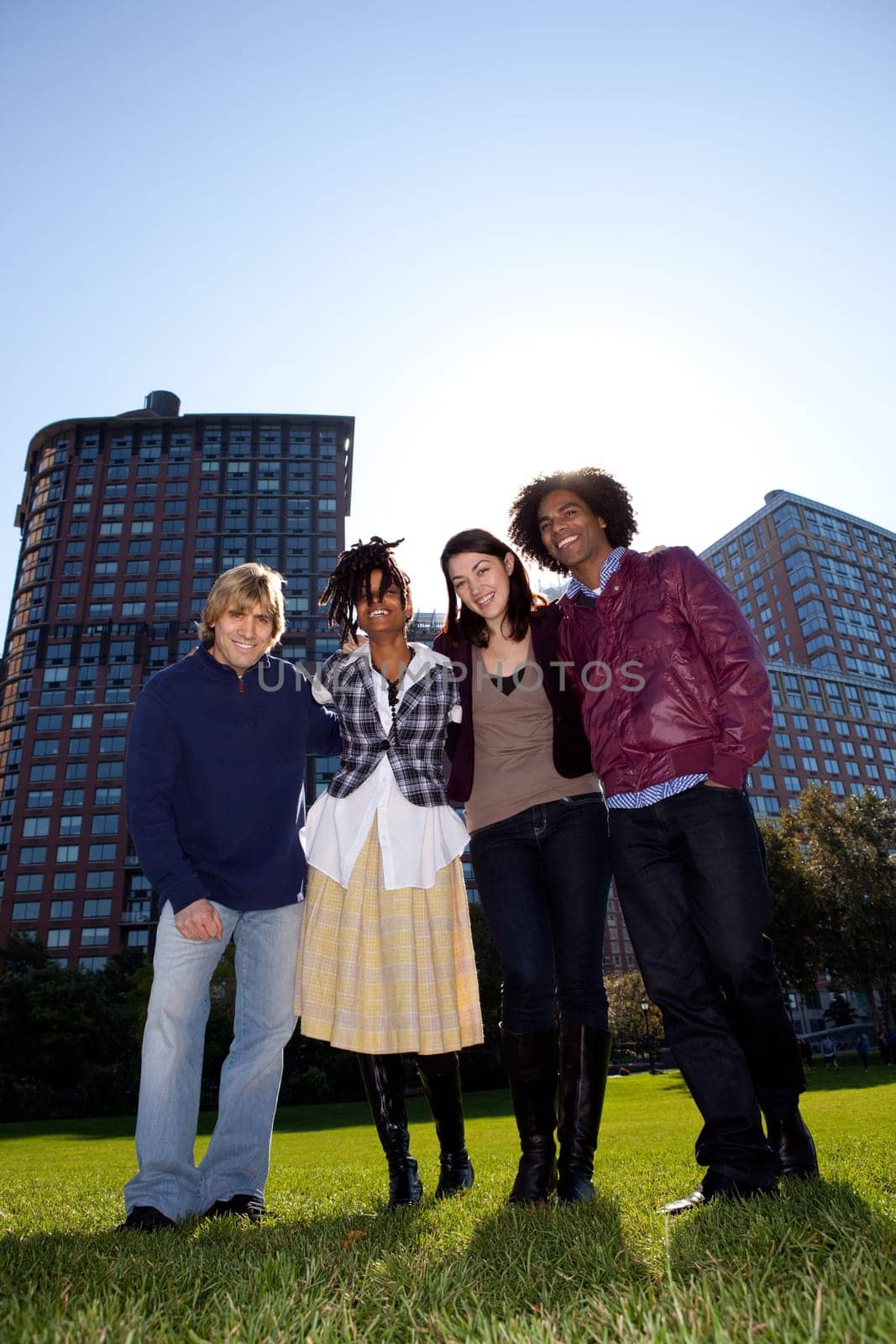 Low angle view of four people in urban park. Vertically framed shot.