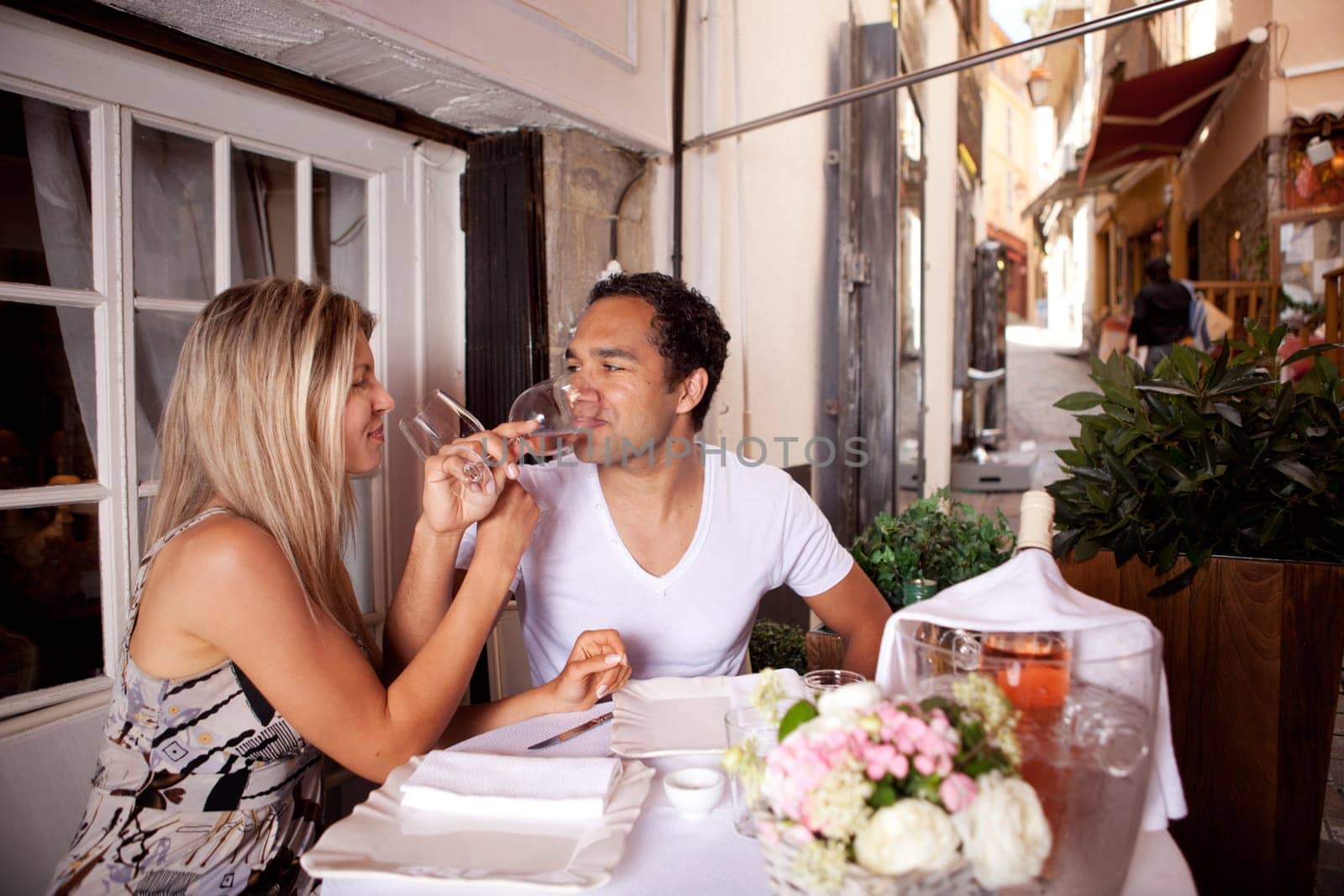 A happy couple drinking wine in a cafe in France