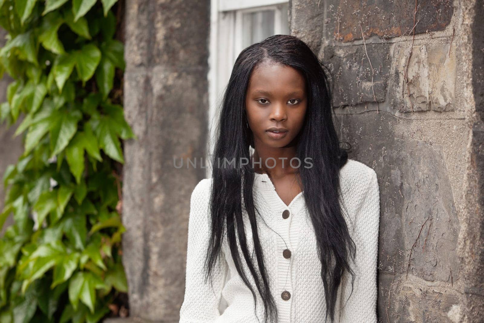 Portrait of African American female standing against stone wall