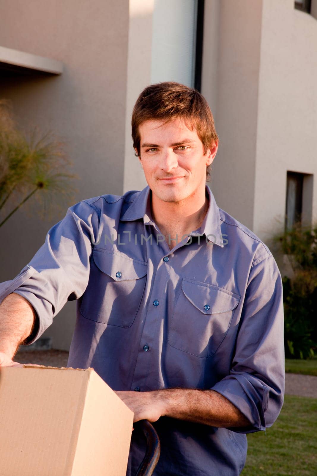 A portrait of a man with moving boxes on a trolly