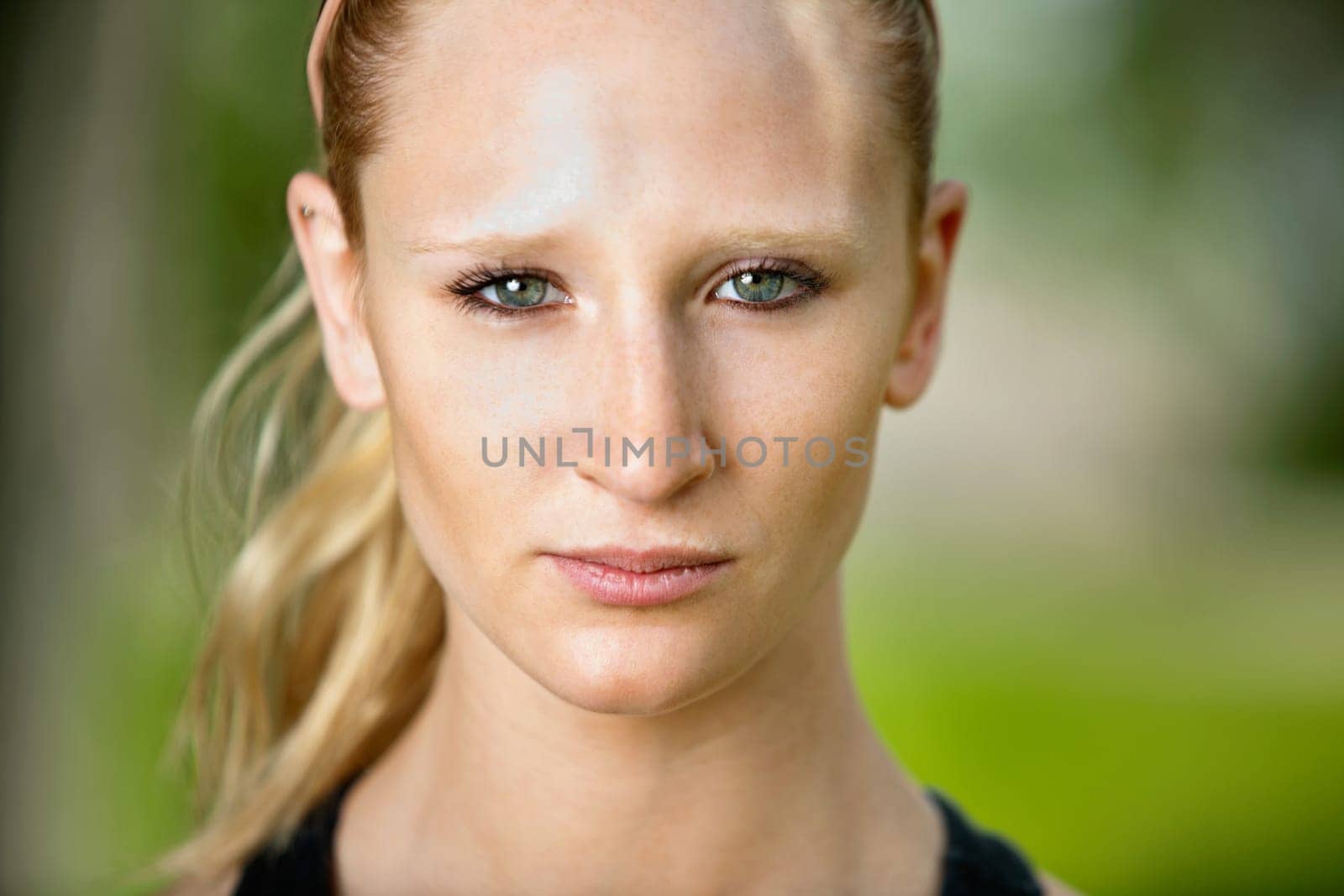 Close-up portrait of young serious woman against blur background
