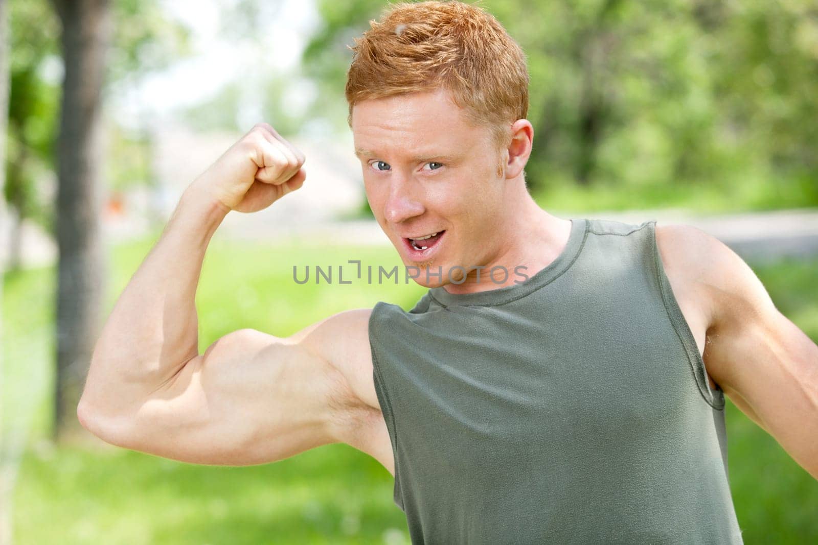Young muscular man showing his biceps against blur background