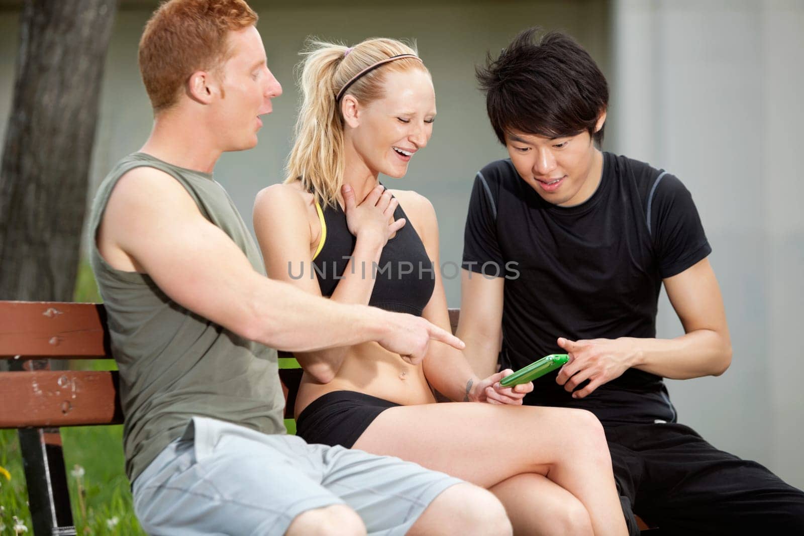 Portrait of three friends playing around with a mobile phone