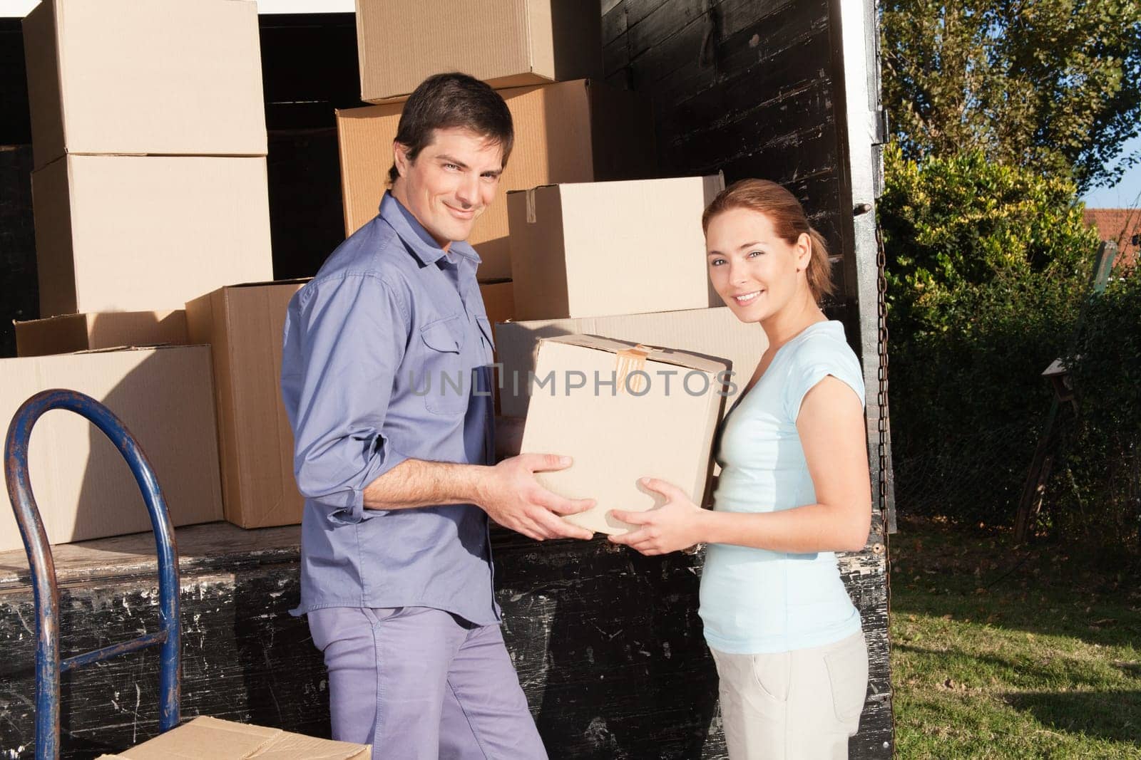 Smiling couple moving luggage at their new house