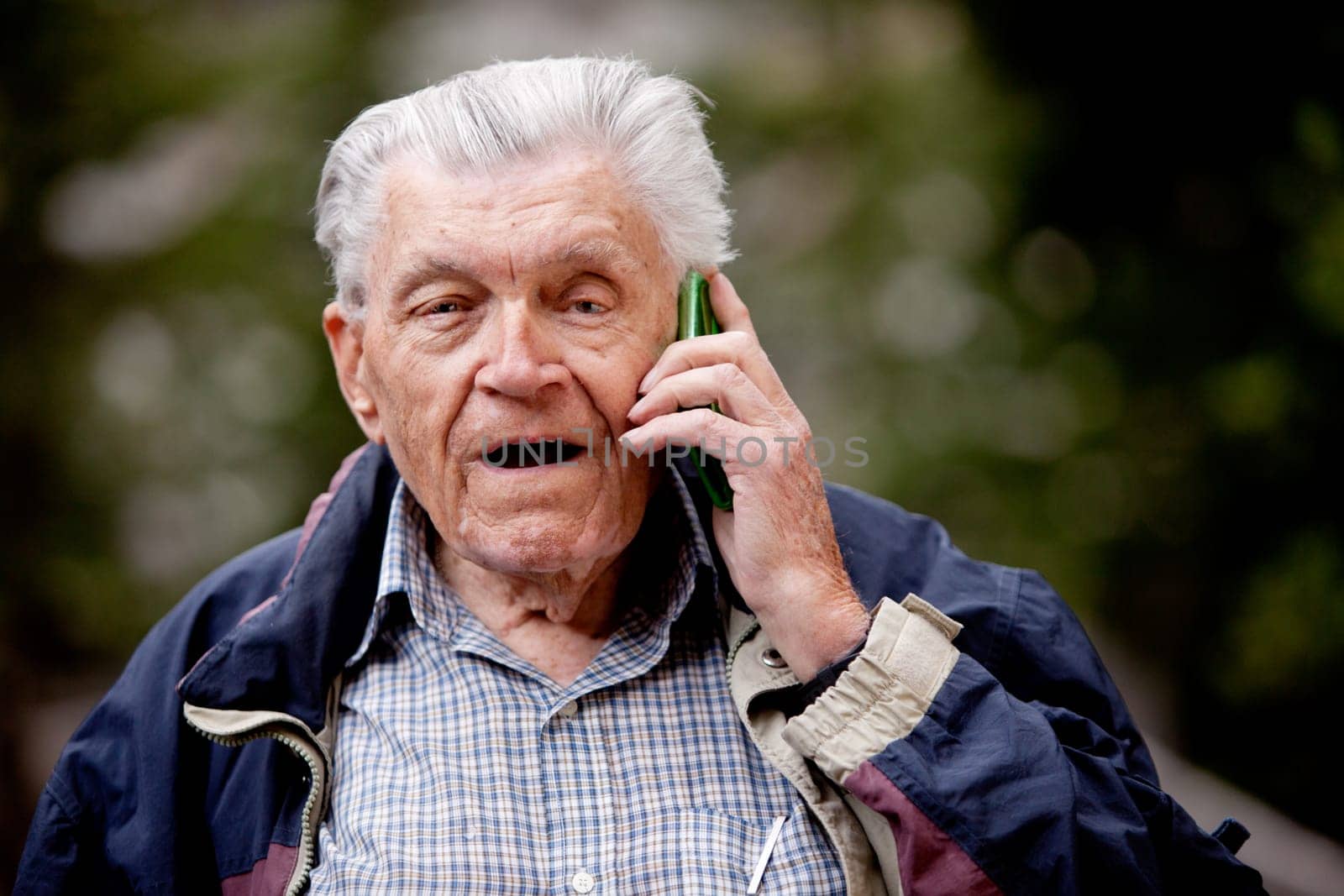 A senior talking on a cell phone outdoors