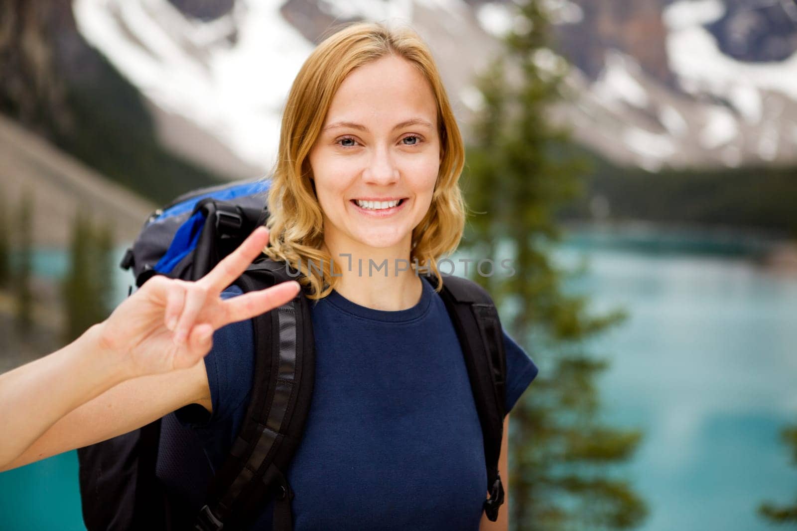 A portrait of a happy smiling girl with a mountain lake in the distant background